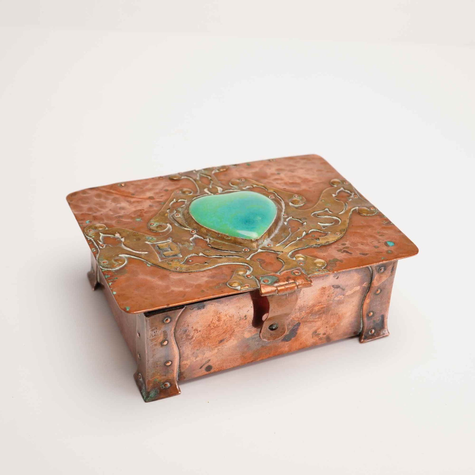 Art Nouveau Monogrammed Copper Trinket Box with Stone Inlay and Velvet Interior: This Arts and Crafts period jewelry box is constructed from hammered copper and bronze elements. The rectangular form features a planished surface with prominent riveted corner brackets that extend do