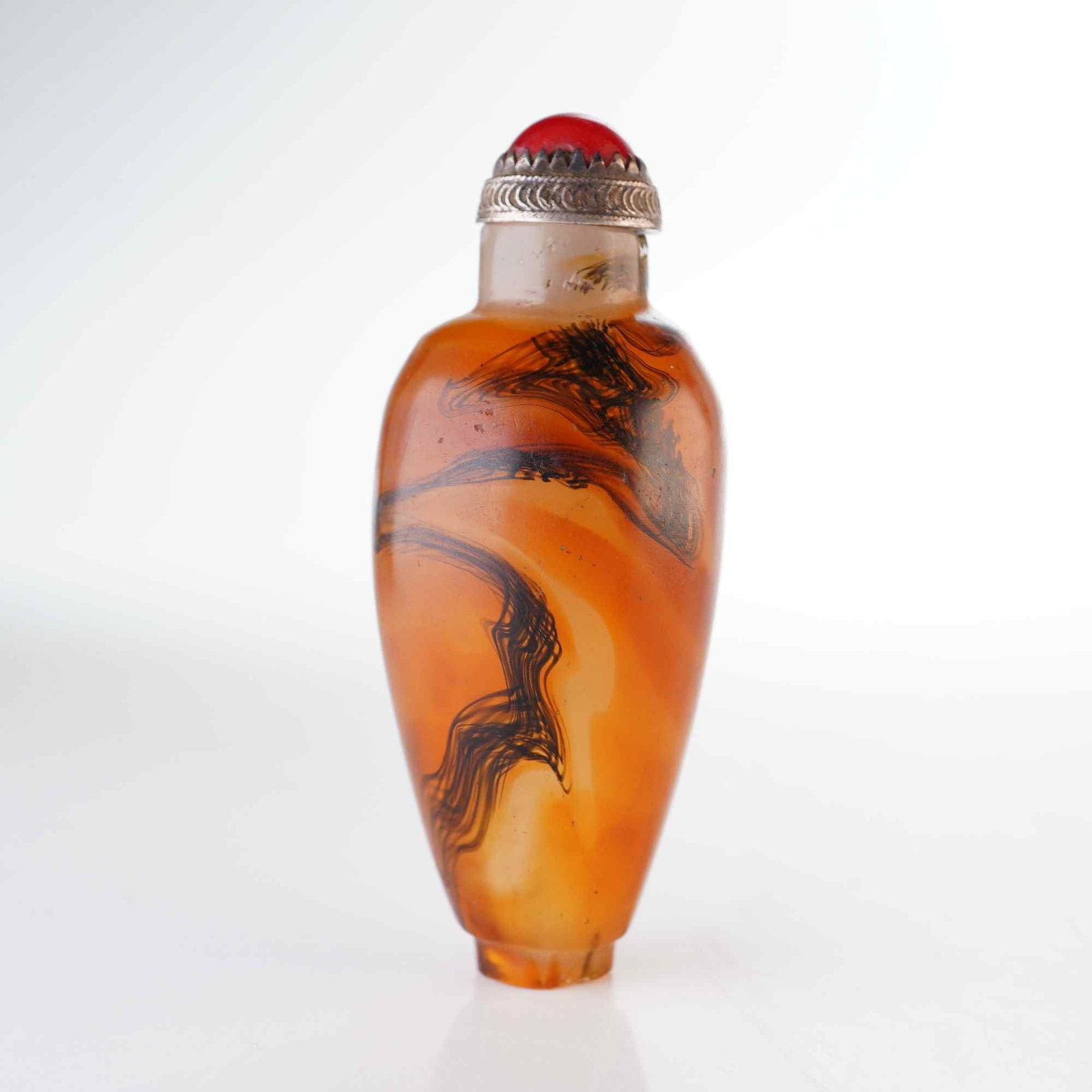 Swirled Glass Snuff Bottle, Ovoid Form, Black and Tan: A tapered ovoid glass snuff bottle featuring a mottled tan and brown ground with black swirls. It is presented with a domed metal stopper topped with a coral-like cabochon. Dimensions: 1"W x 3"H Weigh