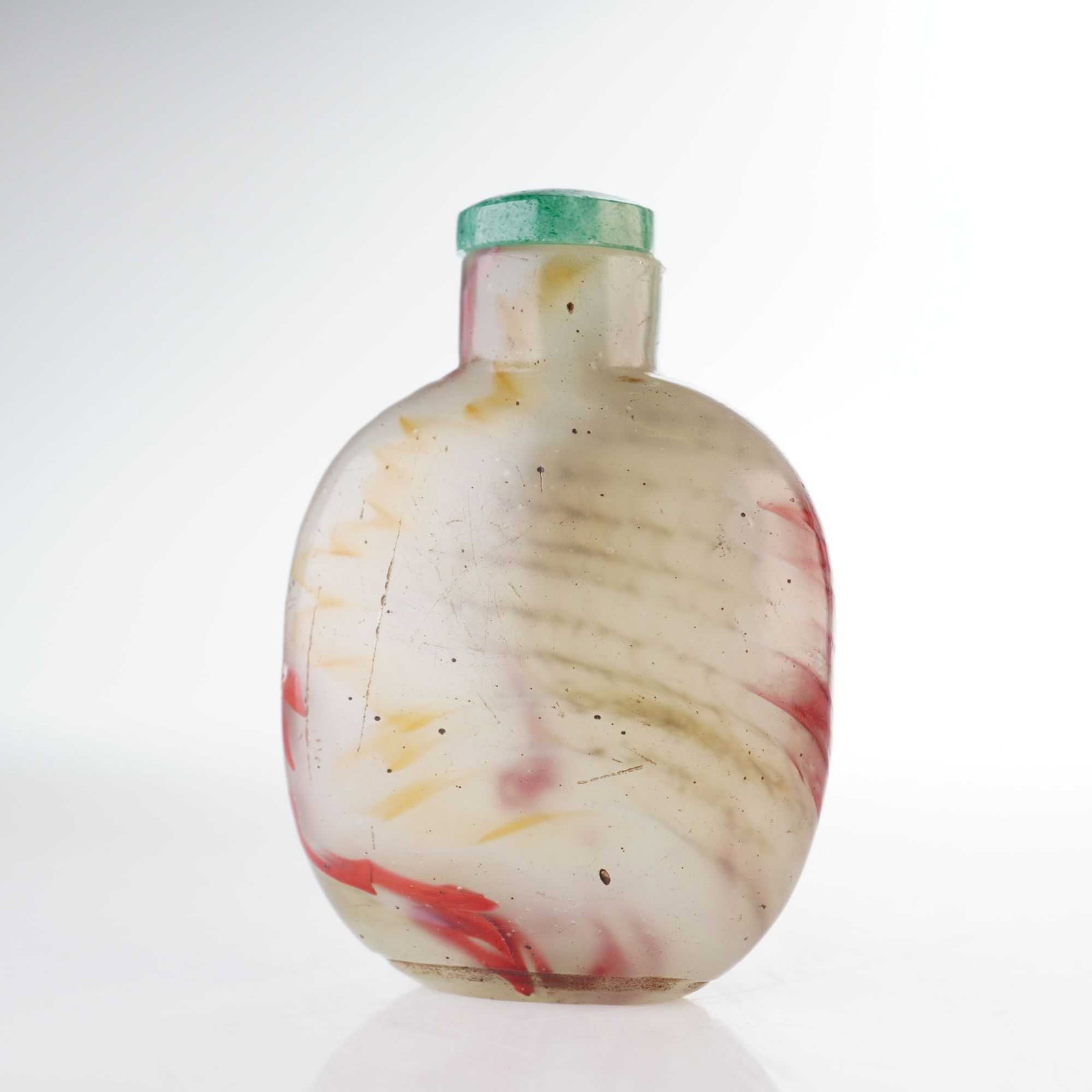Swirled Glass Snuff Bottle, Red, Tan, and Yellow: This rounded glass snuff bottle features swirling, wave-like stripes with mottled color inclusions of red, tan, and yellow. It is presented with a domed green stopper. Dimensions: 2"L x 0.75"W x 2.75"