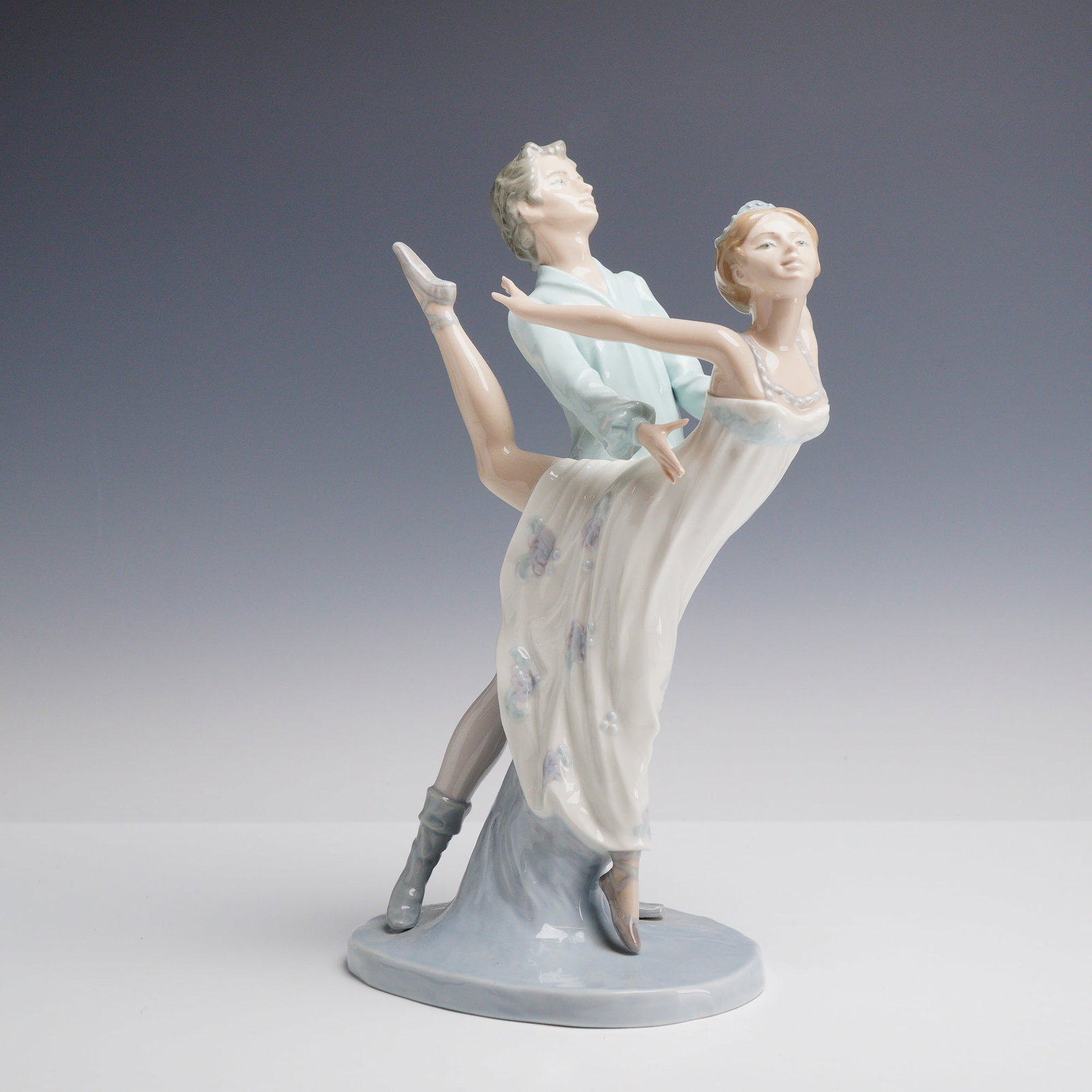 Nao by Lladro Porcelain Figurine Dancing on a Cloud 00400: This Nao by Lladro porcelain figurine is titled Dancing on a Cloud, model number 00400. The piece is constructed of polychrome glazed porcelain and depicts a ballet couple in a performance pose. The m
