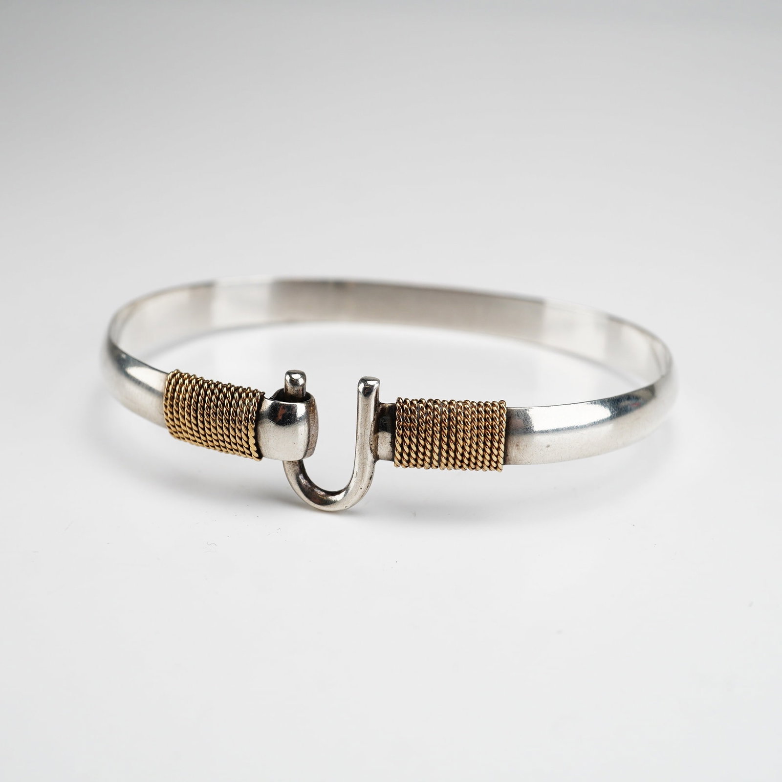 Caribbean Bracelet Company Sterling Silver and 14K Gold Hook Bracelet: This Caribbean hook bracelet is beautifully rendered in sterling silver with a contrasting 14K gold wrap accent. The sleek, curved hook motif, traditionally associated with love, luck, and safe return