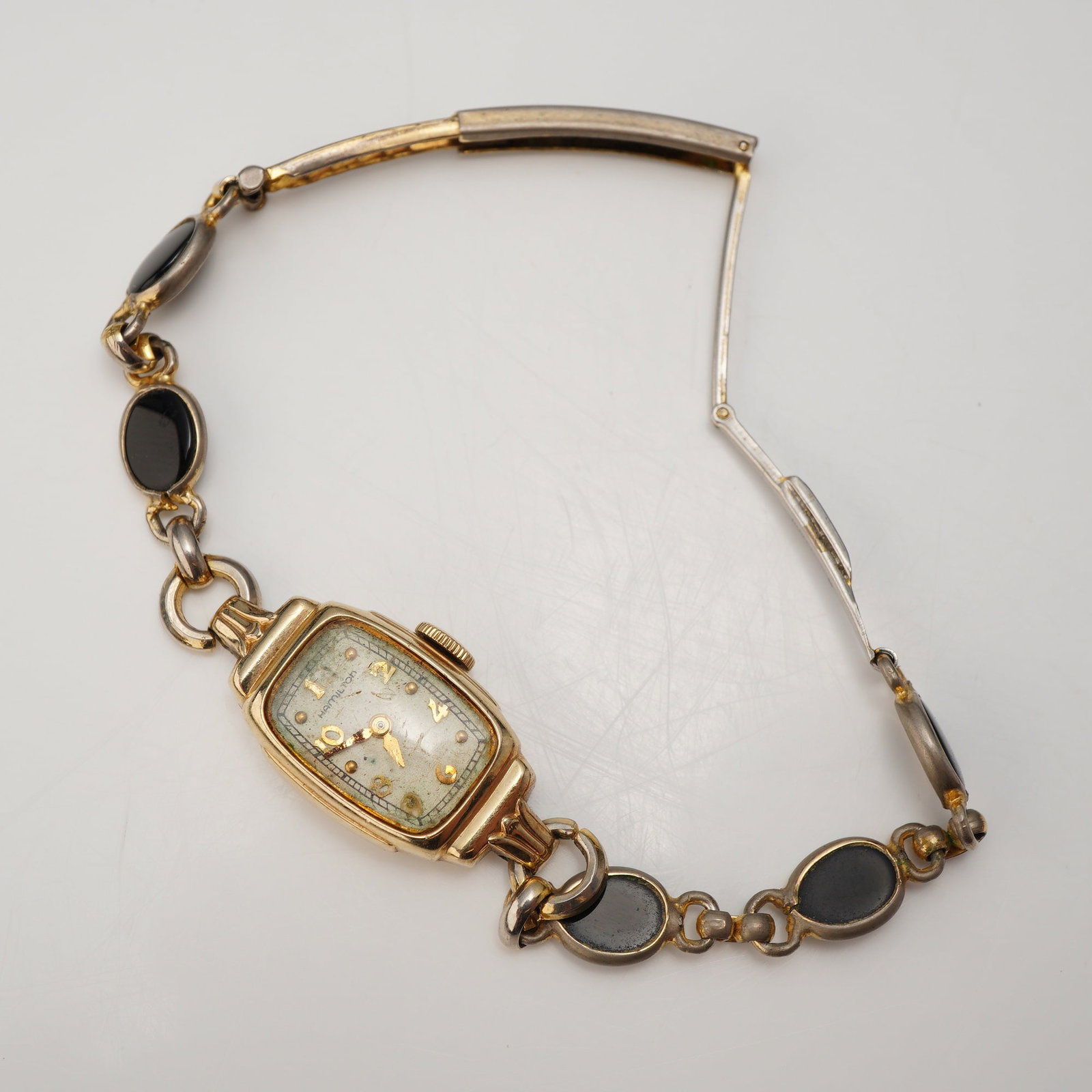Vintage Hamilton Ladies Wristwatch with Hadley 10K Gold Filled Black Cabochon Bracelet: This vintage ladies wristwatch features a gold-tone case and a decorative link bracelet. The dial is marked HAMILTON and features gold-tone applied Arabic numerals at the even positions with dot marke