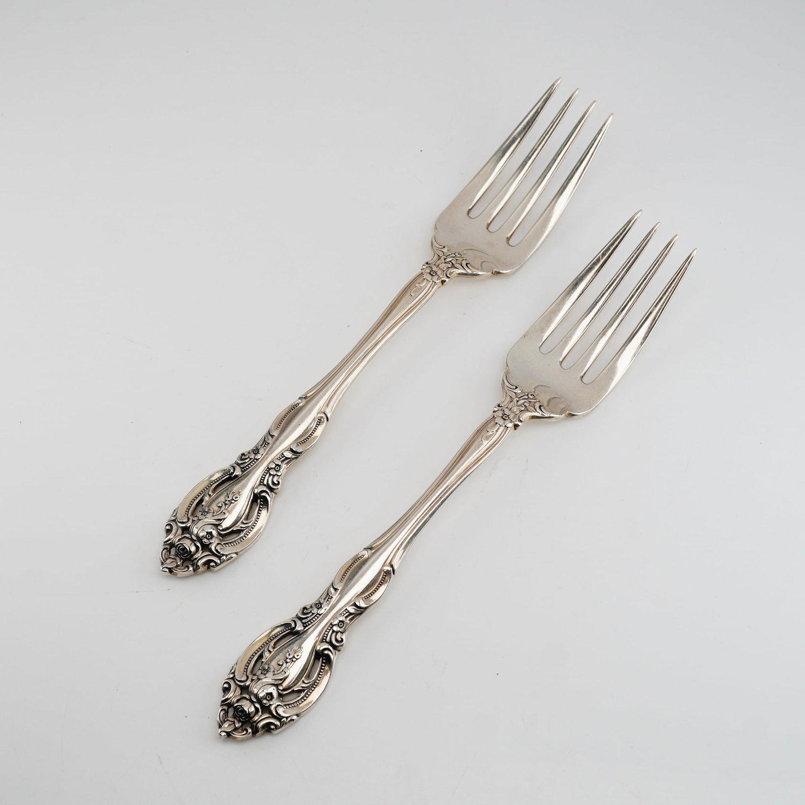 2pc Gorham Sterling Silver Salad Forks, La Scala: The ornate design reflects the Rococo Revival style, featuring elaborate scrollwork and floral accents including rosebuds at the handle terminals. The decoration is present on both the front and back 