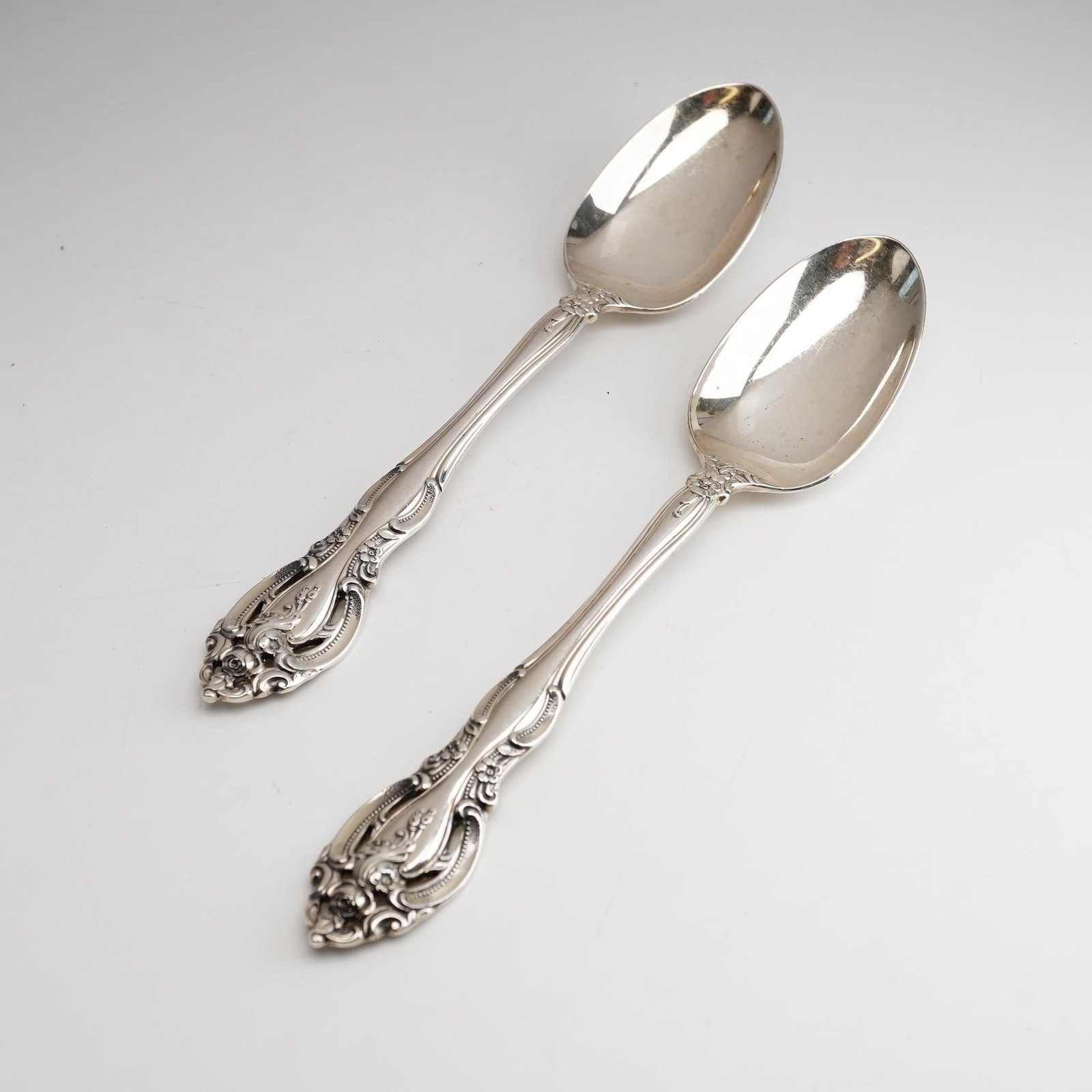 2pc Gorham Sterling Silver Teaspoon, La Scala: An ornate Rococo Revival style featuring heavy scrollwork and floral motifs centered around a rose. The handle terminals are characterized by distinctive pierced openwork detailing. On the reverse of 