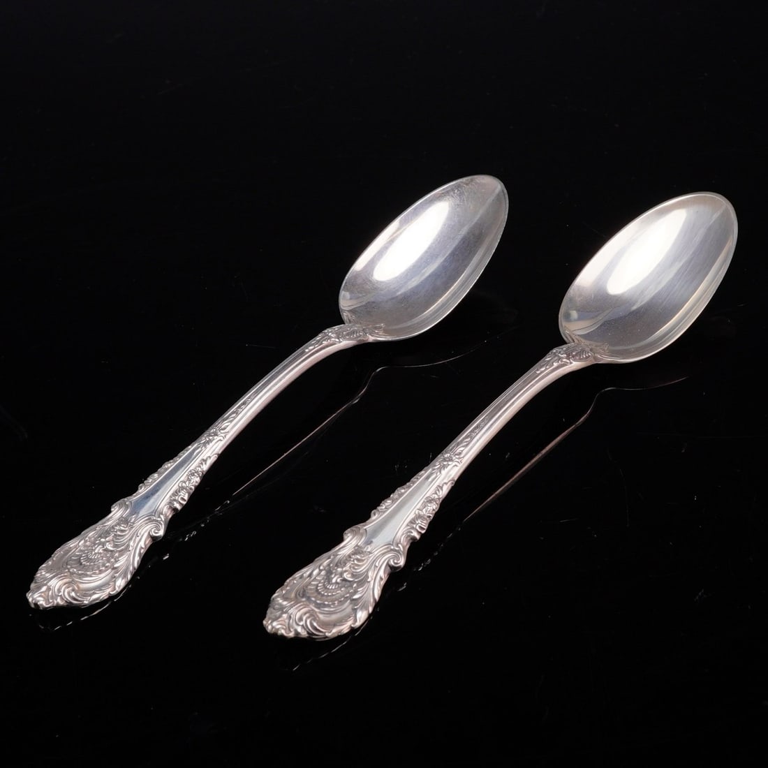 A Pair of Wallace Sir Christopher Sterling Silver Teaspoons: This pair of teaspoons is manufactured by Wallace Silversmiths in the Sir Christopher pattern. The pieces are crafted from solid sterling silver and feature an ornate Rococo-influenced design with hea