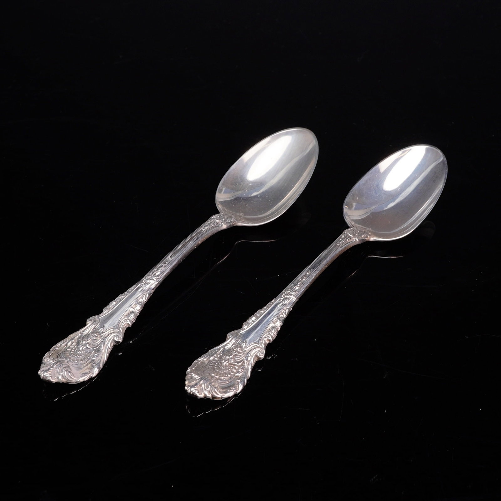 A Pair of Wallace Sterling Silver Dessert Spoons in the Sir Christopher Pattern: A pair of American sterling silver dessert spoons manufactured by Wallace Silversmiths. The spoons are in the Sir Christopher pattern, designed by William S. Warren and introduced in 1936. This patter