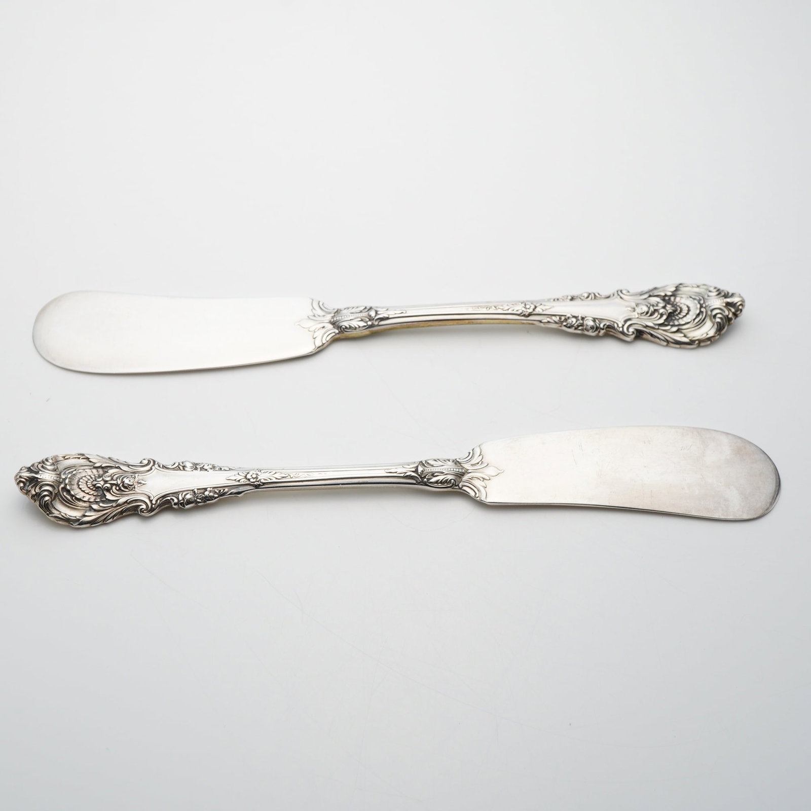 A Pair of Wallace Sterling Silver Sir Christopher Pattern Flat Handle Butter Spreaders: This lot consists of two solid sterling silver flat handle butter spreaders in the Sir Christopher pattern, produced by Wallace Silversmiths. Introduced in 1936, the Sir Christopher pattern is a Renai