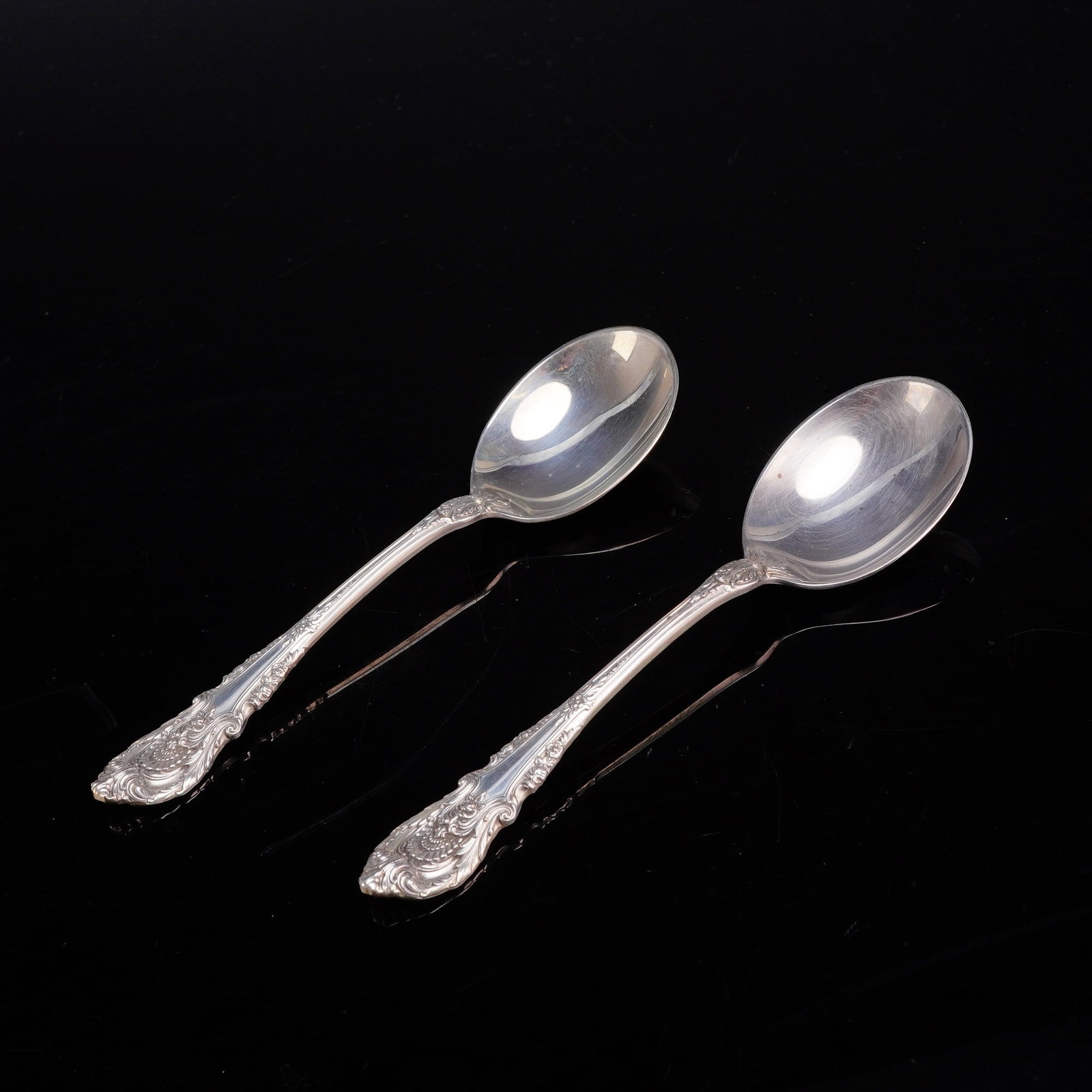 A Pair of Wallace Sterling Silver Soup Spoons in the Sir Christopher Pattern: A pair of oval soup spoons manufactured by Wallace Silversmiths in the Sir Christopher pattern. Each spoon is crafted from solid .925 sterling silver. The Sir Christopher pattern, introduced in 1936, 