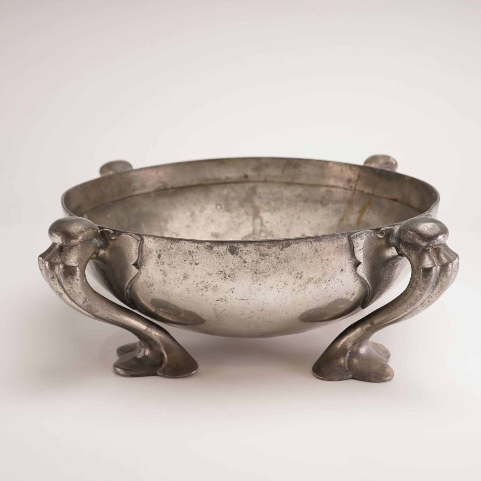 Liberty and Co. by Oliver Baker Tudric Pewter Centerpiece Bowl, c. 1904-1905: This Arts and Crafts pewter bowl was manufactured for Liberty and Co. as part of the Tudric line, produced by W.H. Haseler. The specific design, identified by model number 067, was created by Oliver B