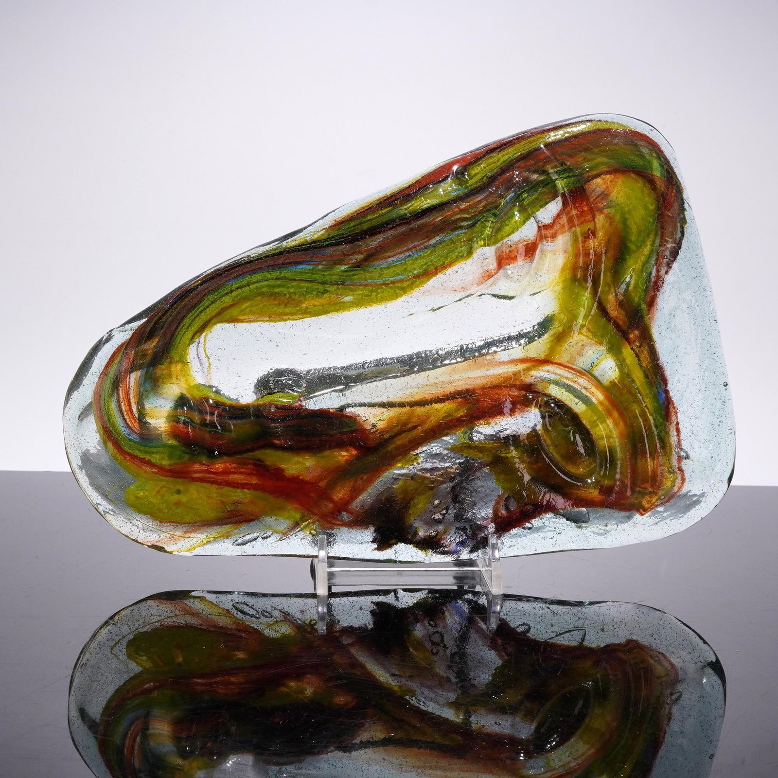 Colored Swirls Art Glass Face Sculpture: The piece features an abstract face motif, including a visible eye structure, rendered through internal multi-colored glass swirls. The thick-walled, irregularly shaped clear glass body is characteriz