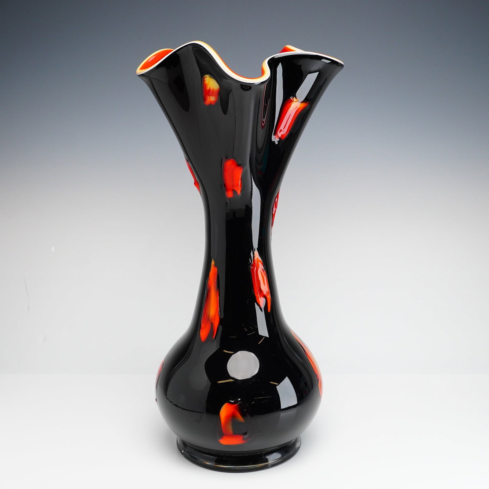 Essie Zareh Baijan Black and Orange Glass Vase: The piece is constructed using a hand-blown, multi-layer cased glass technique. The interior is a solid vibrant orange, followed by a thin white layer, and finished with an opaque black exterior. The 