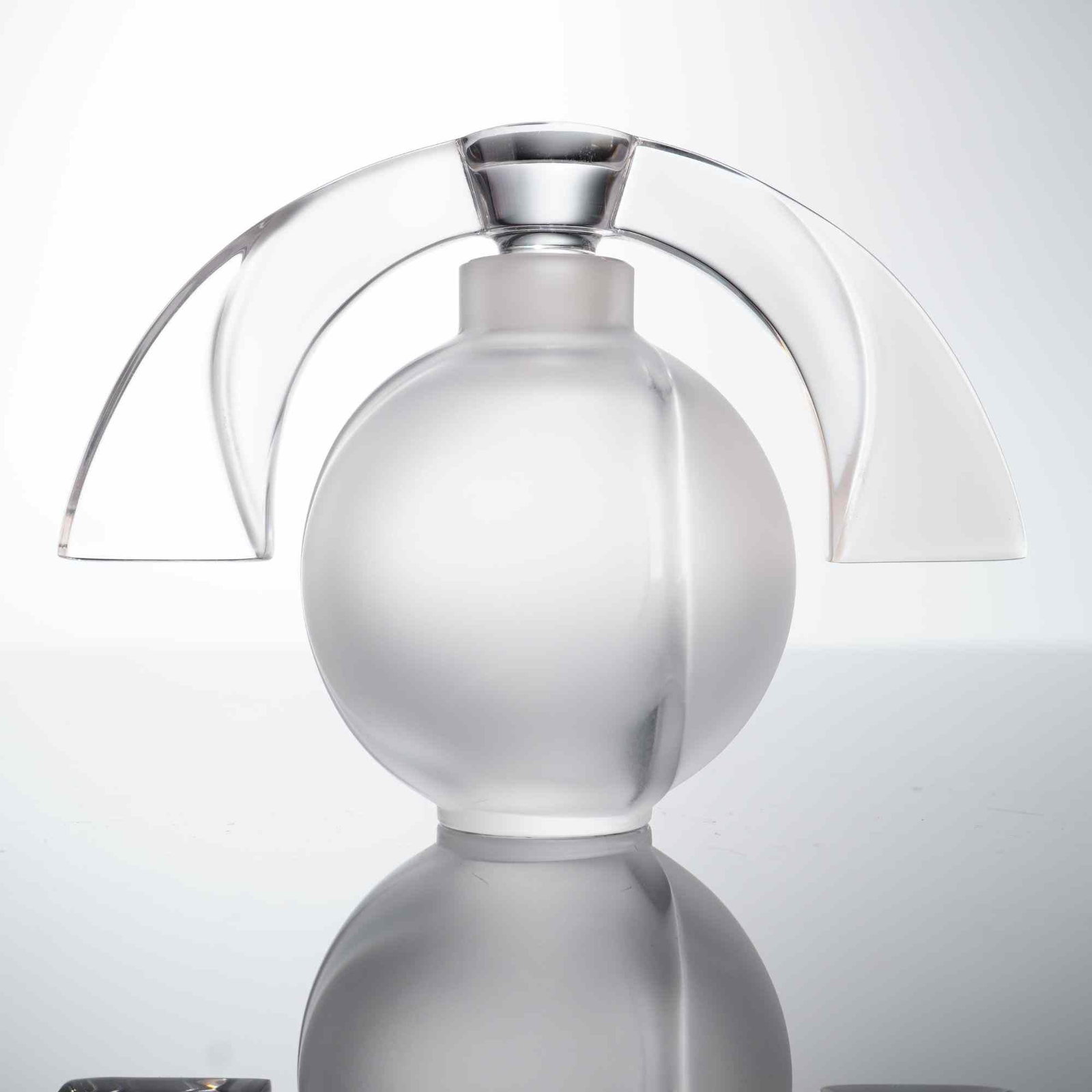 Lalique Society of America 1994 Crystal Perfume Bottle with Stopper, Eclipse: This Lalique crystal perfume bottle is the Eclipse pattern, produced as a 1994 limited edition for the Lalique Society of America. The piece features a spherical frosted glass body with two molded ver