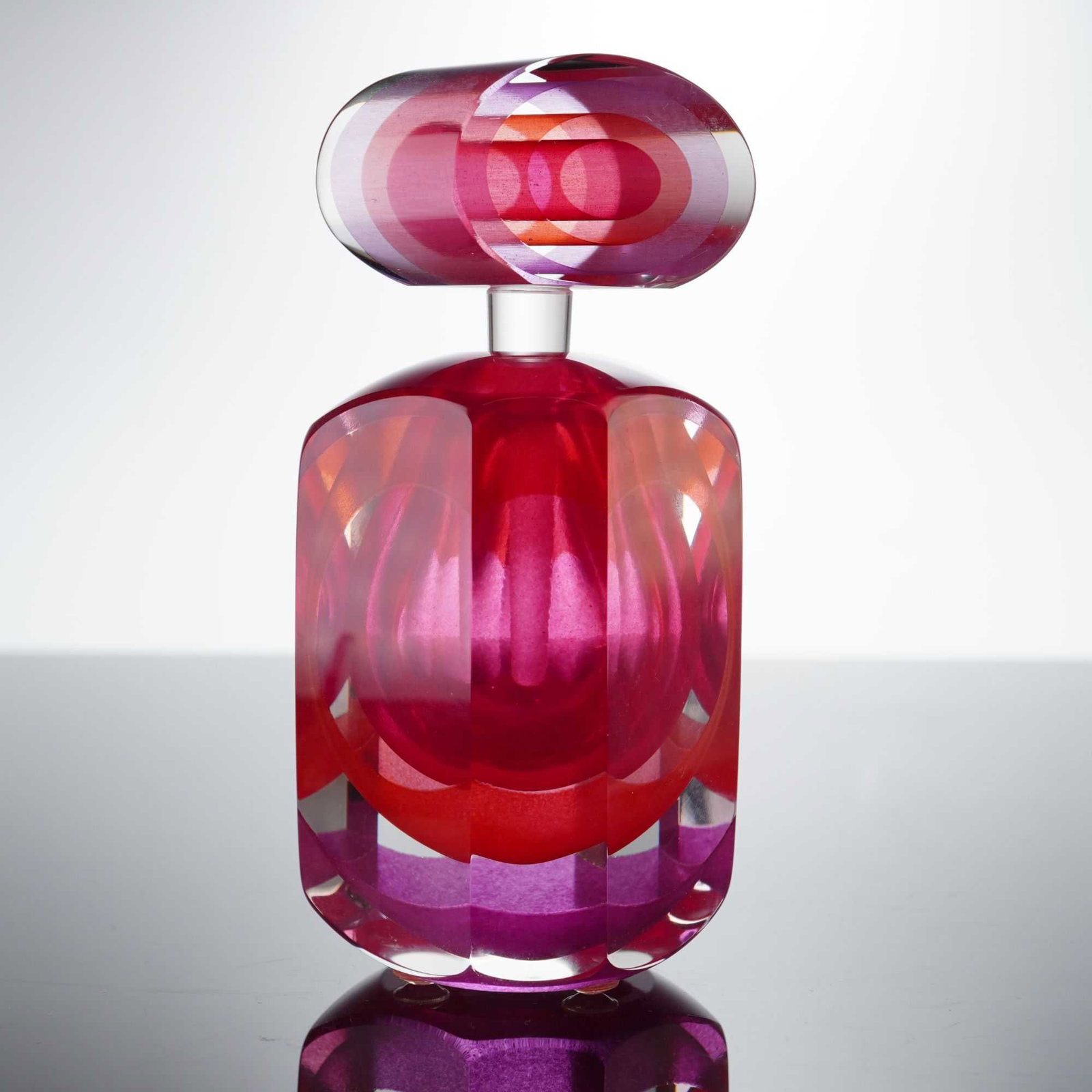 Paul Harrie Art Glass Perfume Bottle with Stopper, Rose PH7Z: The piece is constructed from heavy, clear glass using an internal multi-layered casing technique in a rose colorway, featuring vibrant shades of pink, fuchsia, and orange. The body is formed into a f