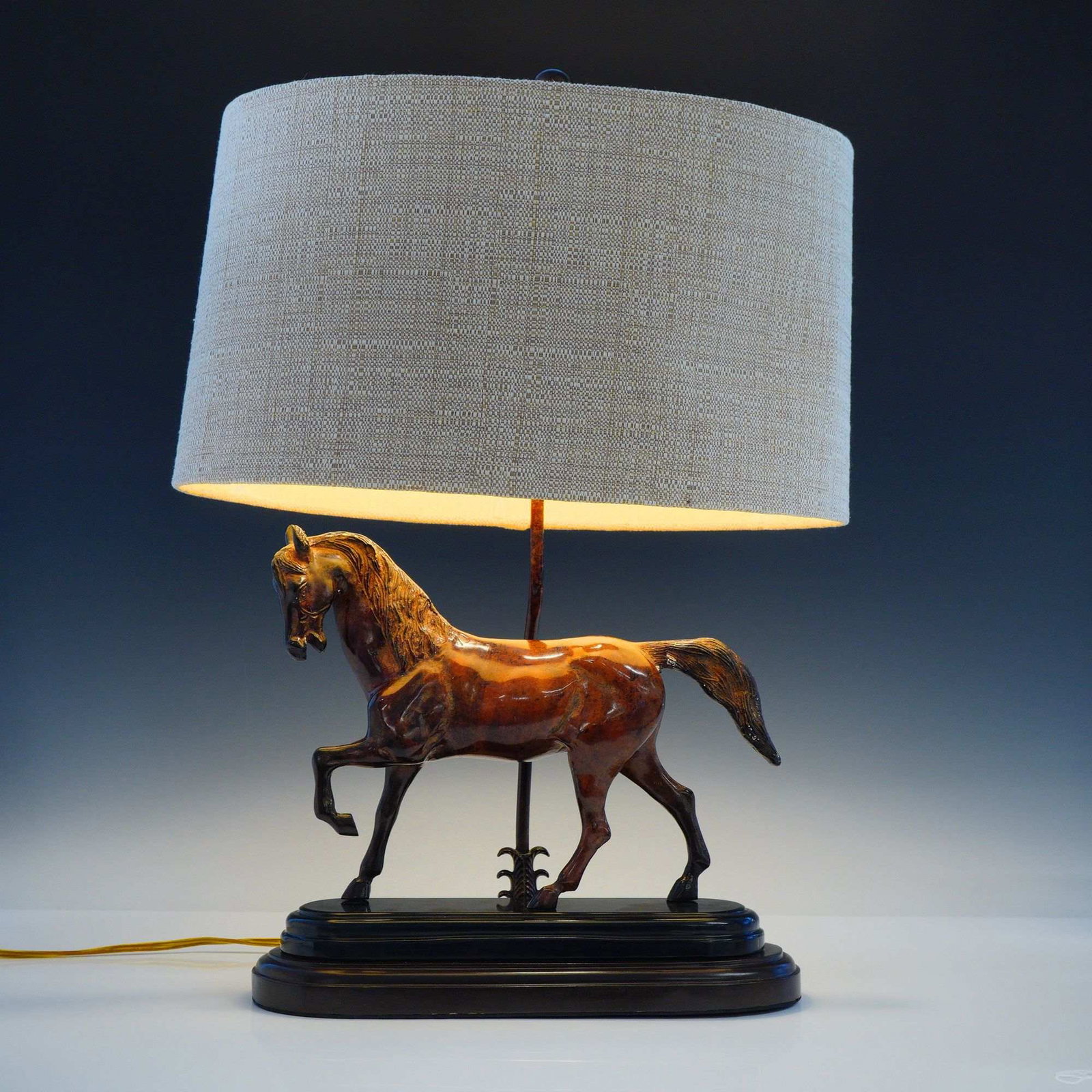 Frederick Cooper Tang Dynasty Style Horse Table Lamp with Shade: This table lamp is attributed to Frederick Cooper and features a cast metal sculpture of a horse in the Tang Dynasty style. The horse figure is finished with a glossy, hand-painted brown surface desig