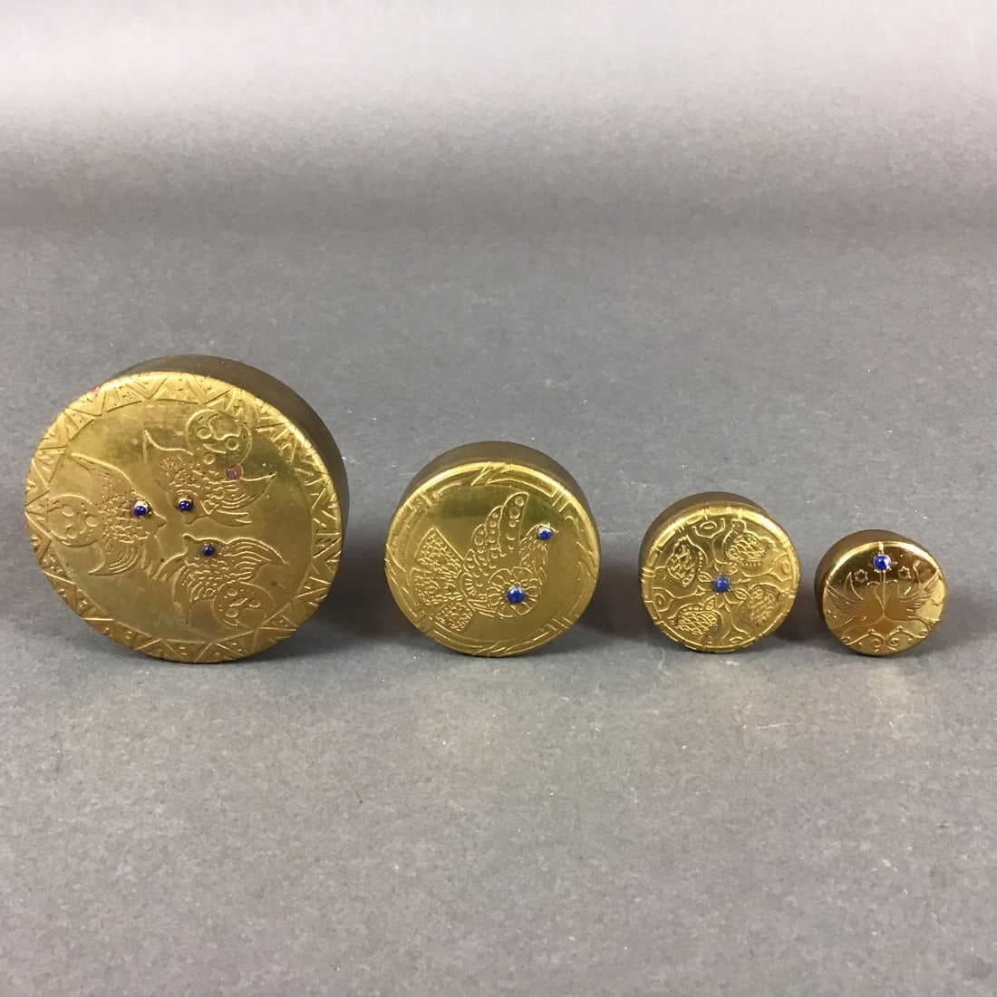 4pc Tognarelli Chile Brass and Lapis Lazuli Inlay Pill Boxes: This 4pc group of graduated circular pill boxes was manufactured by Tognarelli in Chile. Each box is constructed from gold-plated brass and features lapis lazuli inlay. The removable lids are decorate