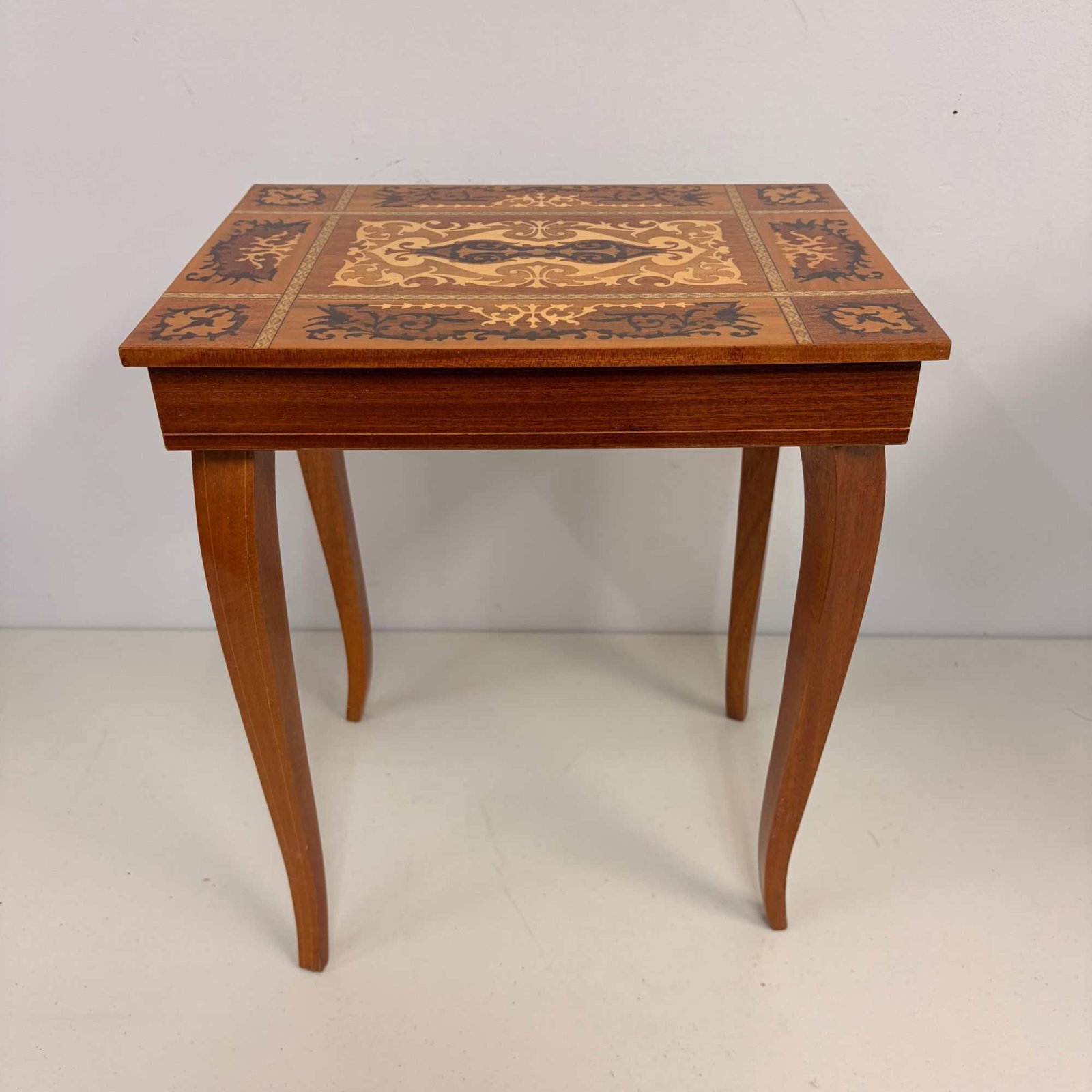 Italian Marquetry Inlaid Musical Side Table with Storage Jewelry Compartments: This Italian Sorrento-style musical side table is constructed of mixed hardwoods featuring elaborate marquetry and parquetry veneer work. The rectangular hinged top is decorated with a complex marquet