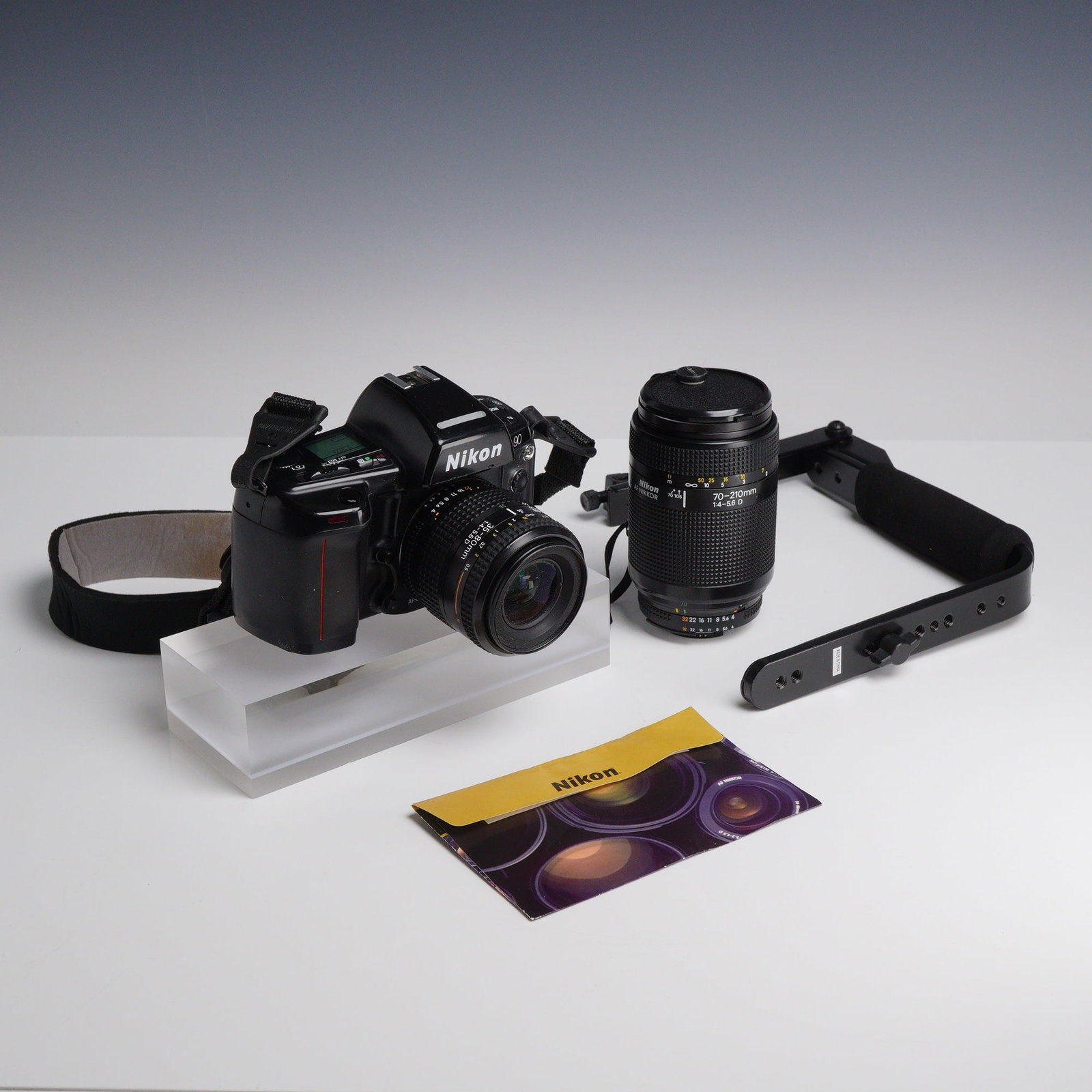 3pc Photography Items Including Nikon N90 Camera with Two Lenses, Accessories, Manual: This lot consists of three photography items featuring a Nikon N90 35mm film SLR camera body. The Nikon N90, known as the F90 in international markets, is a professional-grade autofocus camera featuri