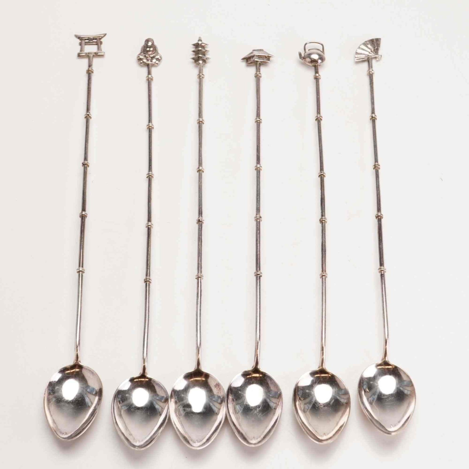 6pc Japanese Sterling Silver Iced Tea Spoons with Figural Finials: A set of six sterling silver iced tea spoons featuring decorative elements inspired by Japanese culture. Each spoon consists of a long, slender handle modeled to resemble a bamboo stalk with periodic 