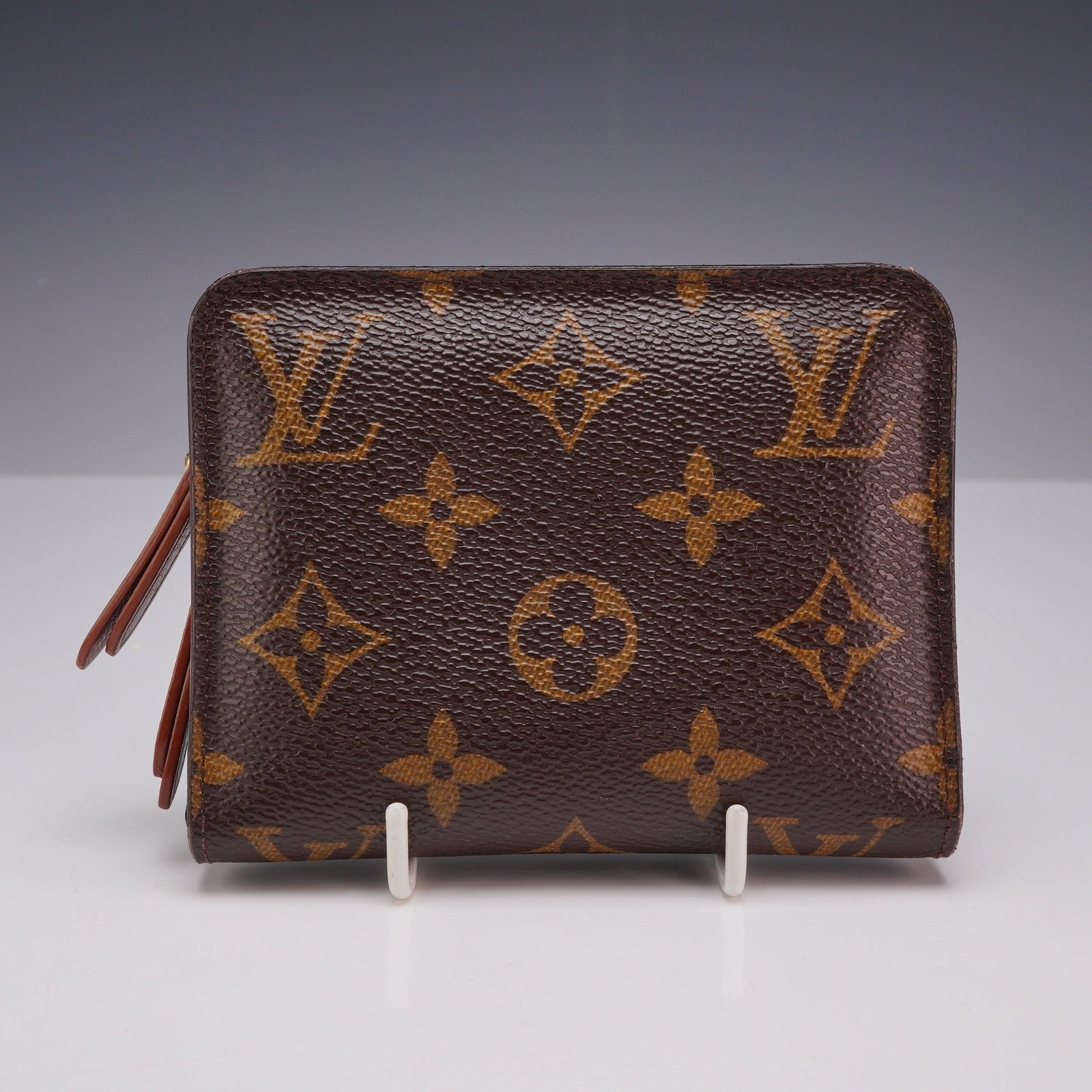 Louis Vuitton Monogram Insolite Coin Purse Wallet: This Louis Vuitton Insolite Coin Purse Wallet is crafted from the iconic Monogram coated canvas. The compact bi-fold design features a terracotta-colored cross-grain leather interior. The layout inclu