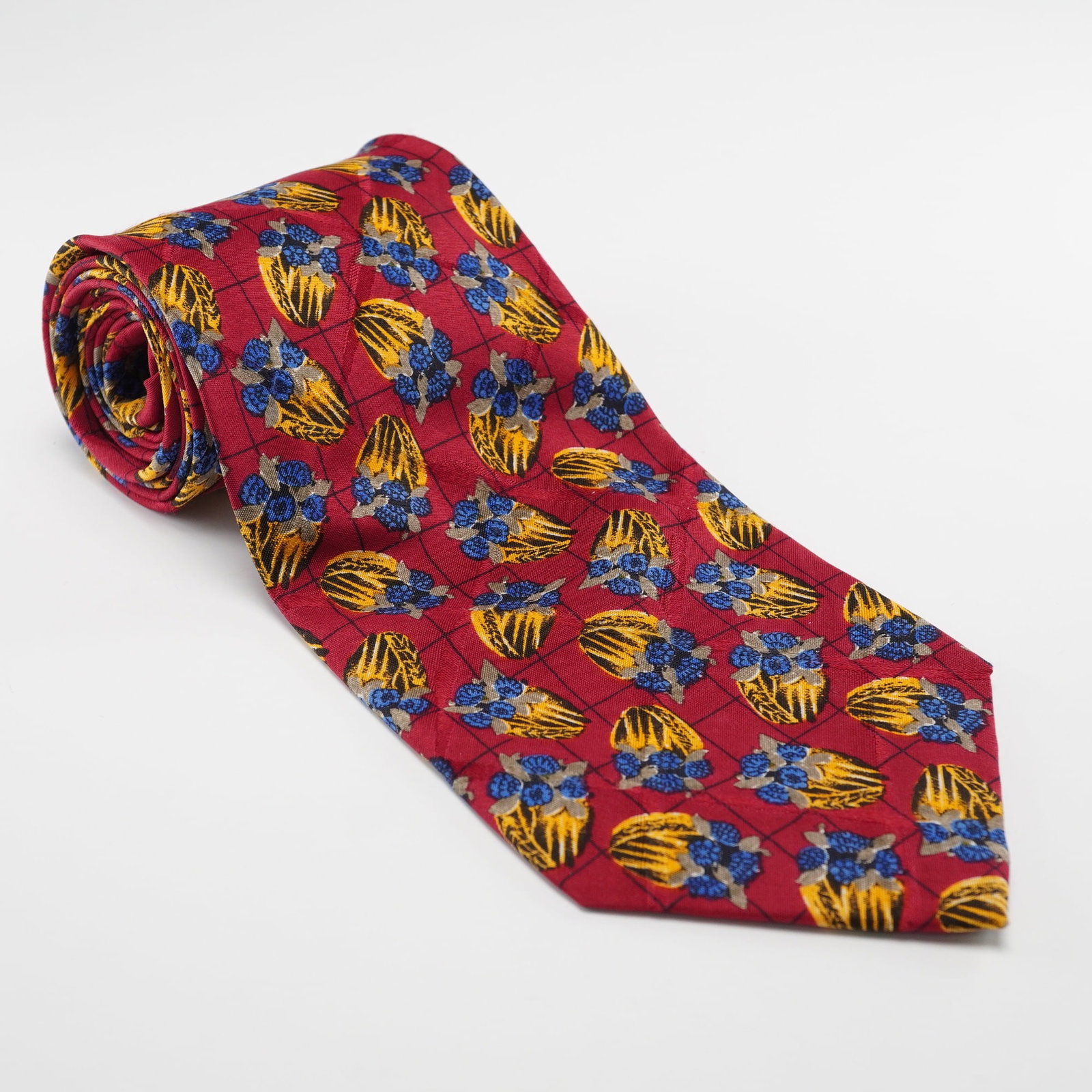 Ungaro Paris Red Silk Necktie with Abstract Floral and Geometric Pattern: A modern Ungaro Paris 100% silk necktie. The tie features a vibrant red ground patterned with a repeating design of abstract blue floral clusters and yellow and black striped shapes, all arranged with