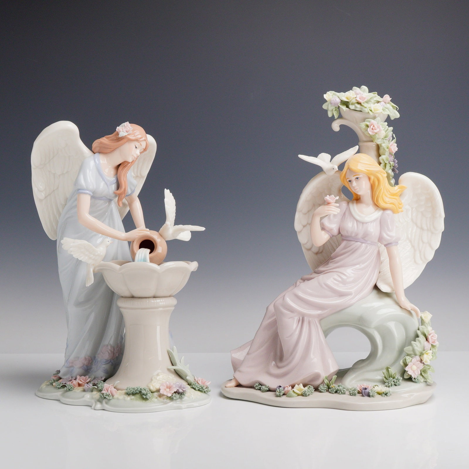 2pc Member's Mark Hand-Painted Porcelain Angel Figurines: This elegant lot features two exquisitely hand-painted, glazed porcelain angel figurines from the Member's Mark Holiday Collection. The first piece showcases a serene blonde angel draped in a soft lav