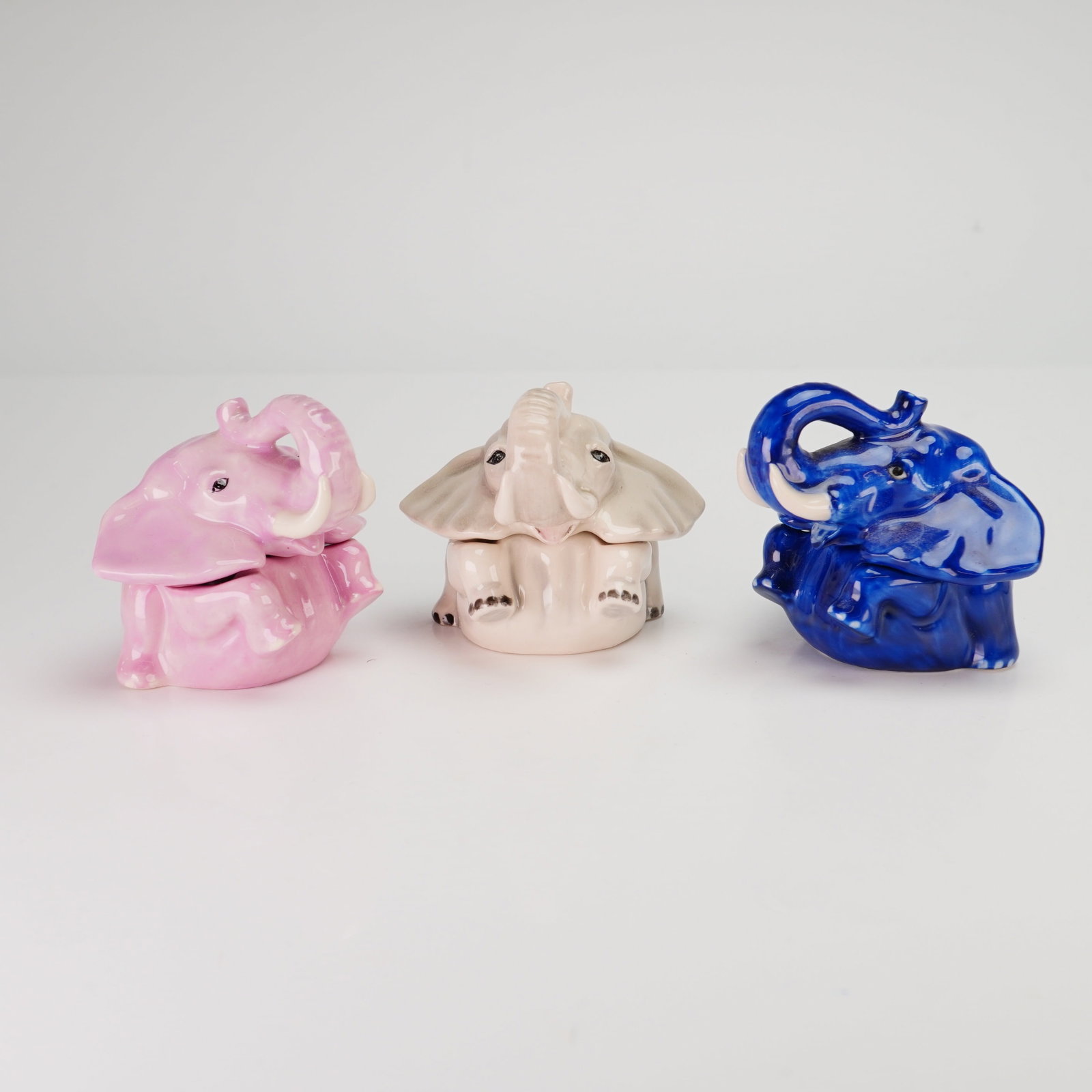 3pc Kevin Francis Ceramic Elephant Face Pots, Hindustan, Lily, and House of Blues: This collection includes three glazed ceramic trinket boxes from the Face Pots line by Kevin Francis, all dated 2001. Each box is a two-piece construction consisting of a base formed by an elephant's 