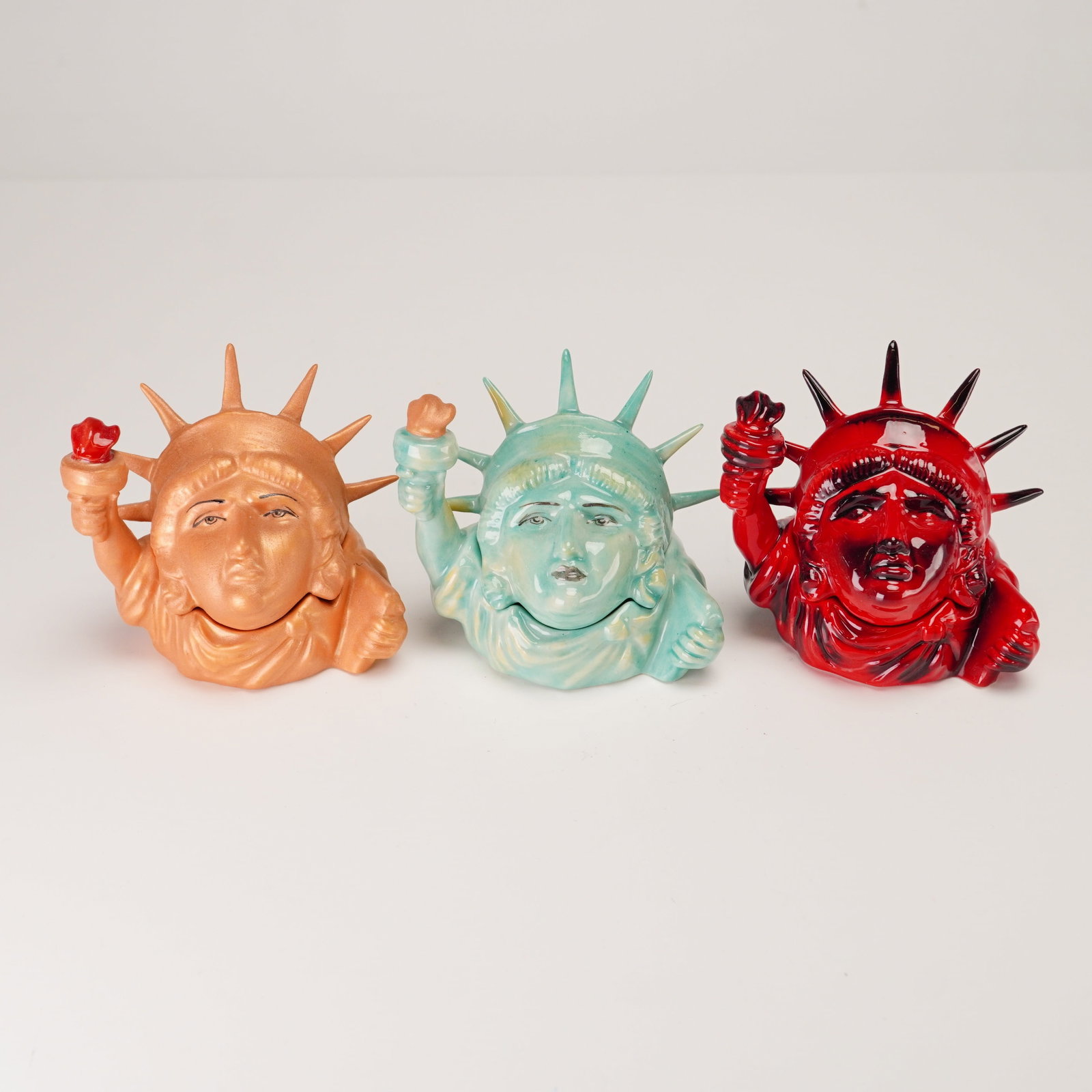 3pc Kevin Francis Ceramic Face Pots, Miss Liberty: A set of three Kevin Francis ceramic Face Pot trinket boxes in the Miss Liberty pattern, dated 2001. Each pot is a two-piece vessel where the lid forms the face and crown of Lady Liberty and the base 