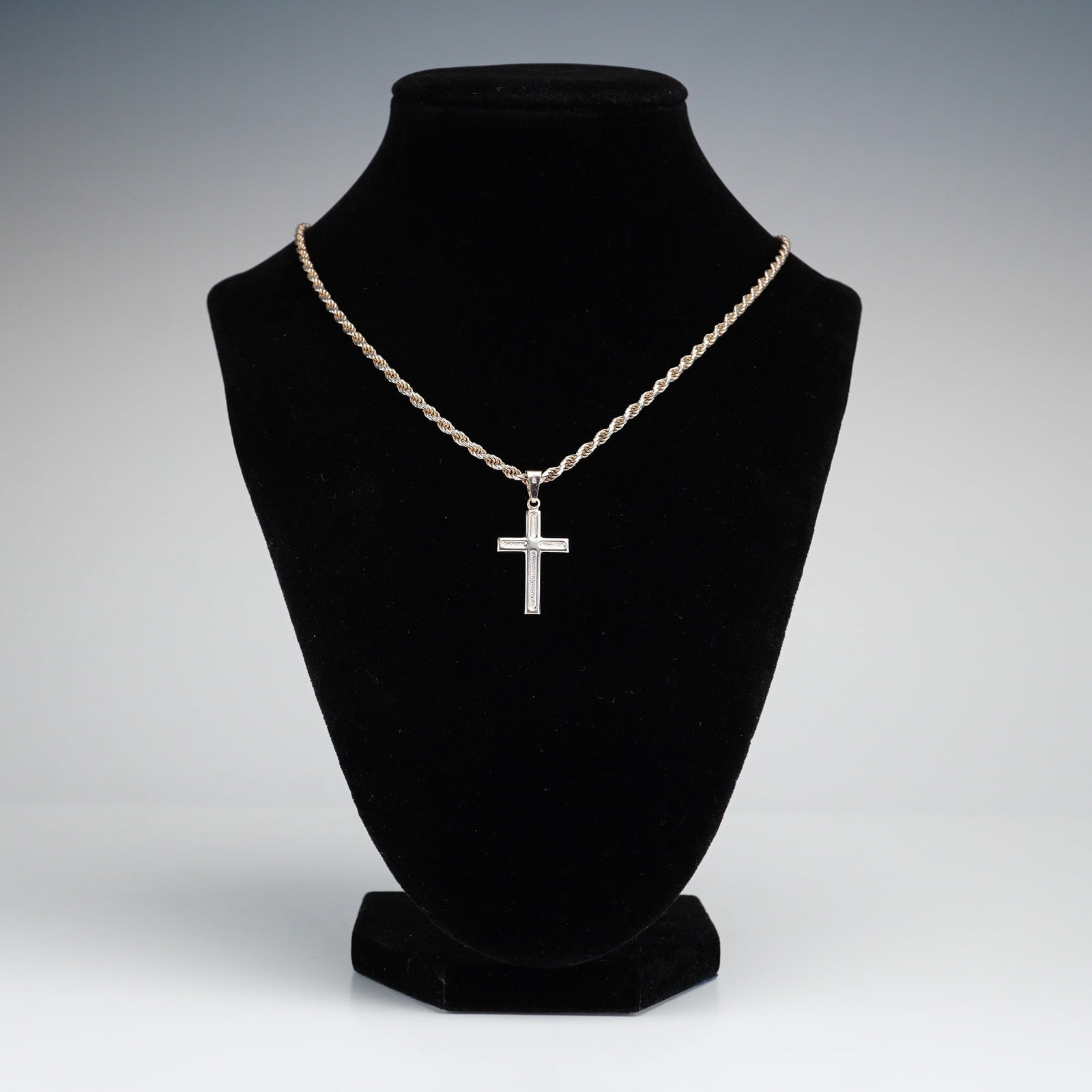 Italian Sunstone Imports 14kt White Gold Cross Pendant on a Sterling Silver Chain Necklace: A cross pendant crafted from 14kt white gold on a sterling silver rope chain necklace. Pendant is marked 14kt and Italy on the bail. Necklace is marked 925, Italy, and SU for Sunstone Imports, Inc. Di