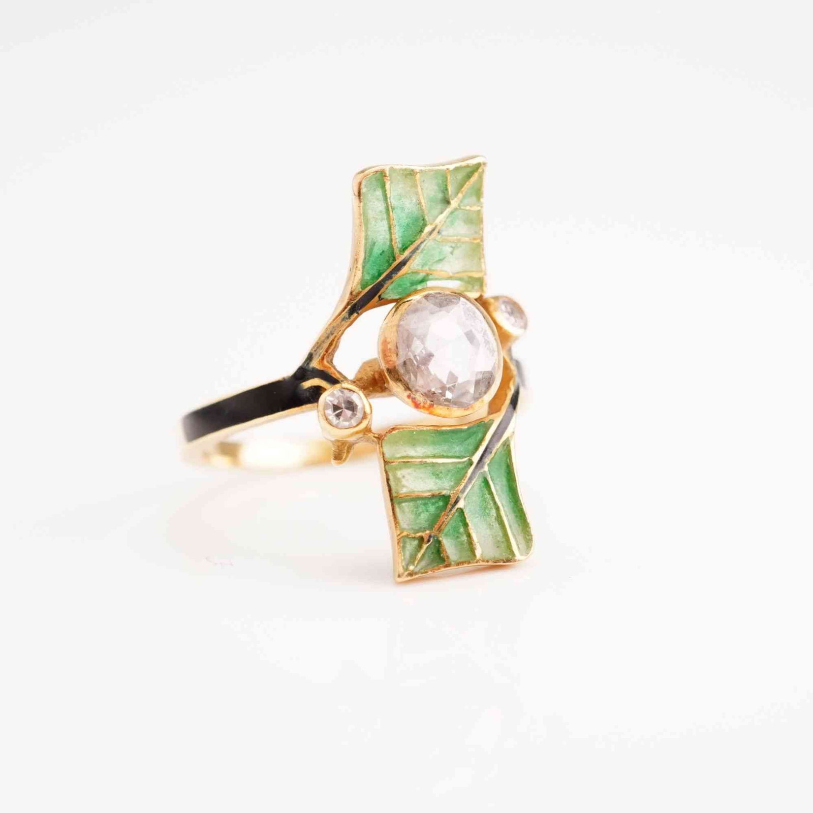 Art Nouveau Style 18K Gold Ring with Rose-Cut Diamonds: An Art Nouveau style botanical ring constructed from 750/18k yellow gold with green enamel accents. The central motif features two rectangular foliate elements decorated with translucent green basse-t