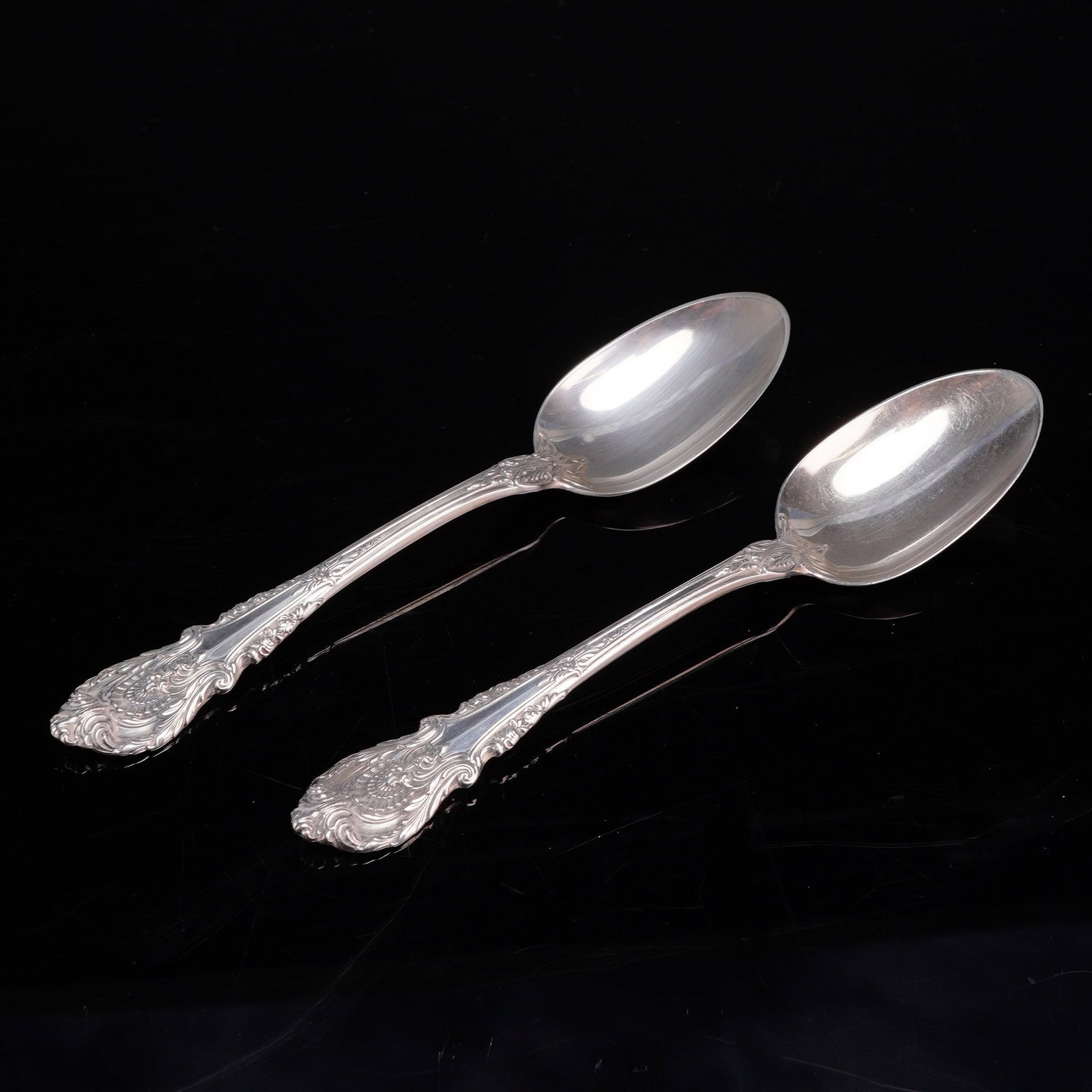 A Pair of Wallace Sterling Silver Dessert Spoons in the Sir Christopher Pattern: A pair of American sterling silver dessert spoons manufactured by Wallace Silversmiths in the Sir Christopher pattern. This pattern, designed by William S. Warren and introduced in 1936, features a ri