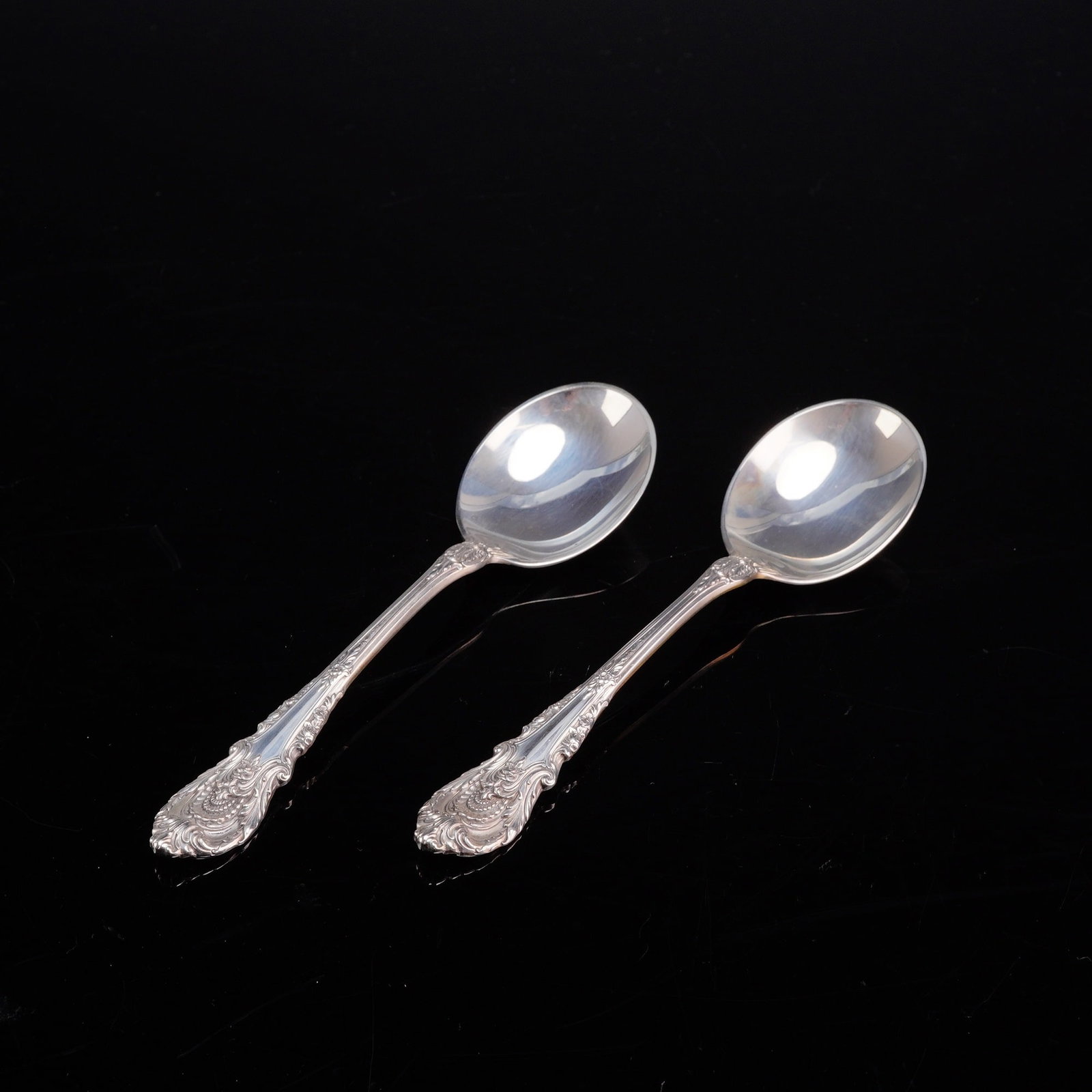 A Pair of Wallace Sterling Silver Soup Spoons in the Sir Christopher Pattern: A pair of Wallace Silversmiths sterling silver soup spoons in the Sir Christopher pattern. These spoons feature circular bowls and cast handles decorated with the ornate Renaissance-style motifs of th