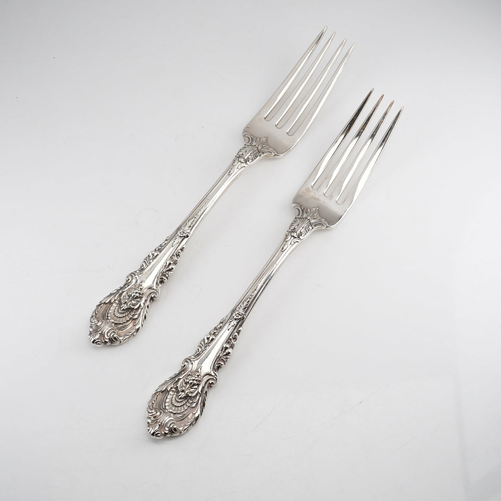 Pair of Wallace Sterling Silver Dinner Forks, Sir Christopher Pattern: Designed by William S. Warren and introduced in 1936, the pattern reflects the English Renaissance style inspired by architect Sir Christopher Wren. The ornate handles feature a central shell motif at