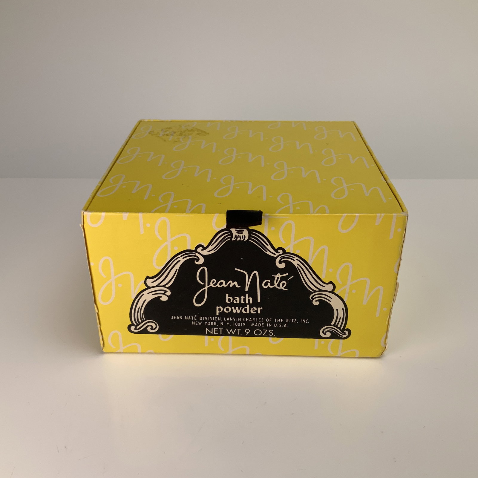 Vintage Jean Nate Bath Powder and Sponge, Lanvin-Charles of the Ritz: Jean Nate bath powder and sponge manufactured by the Jean Nate Division of Lanvin-Charles of the Ritz, Inc. The item is housed in a square yellow cardboard box with a repeating white jn monogram patte