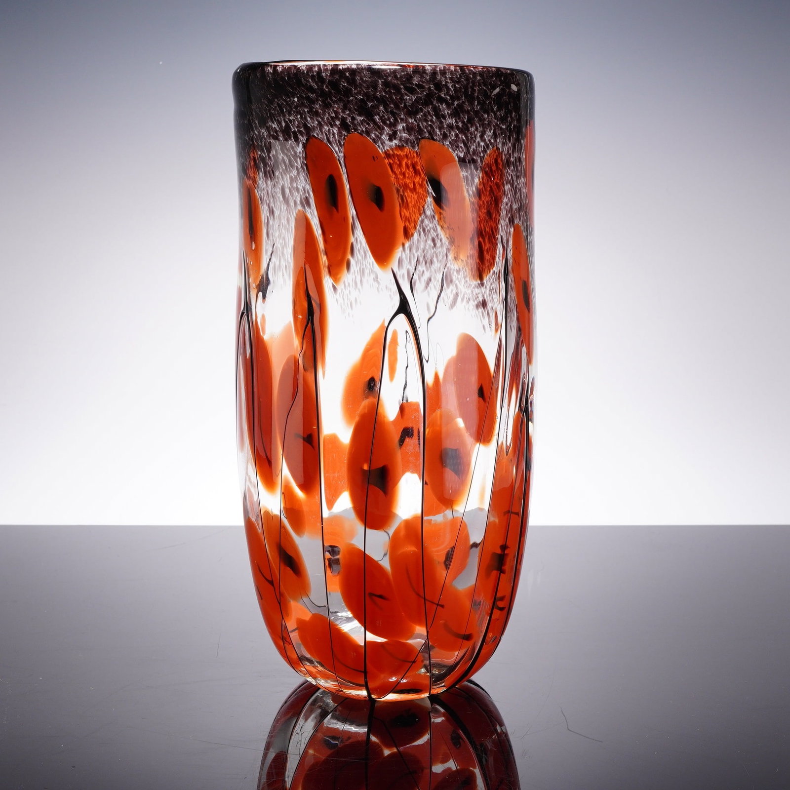 Souffle A La Bouche Poppy Art Glass Vase: This Souffle A La Bouche art glass vase is designed in a tall ovoid form with a slightly tapered, rounded base and a flat, polished rim. The piece is constructed of clear mouth-blown glass. The upper 