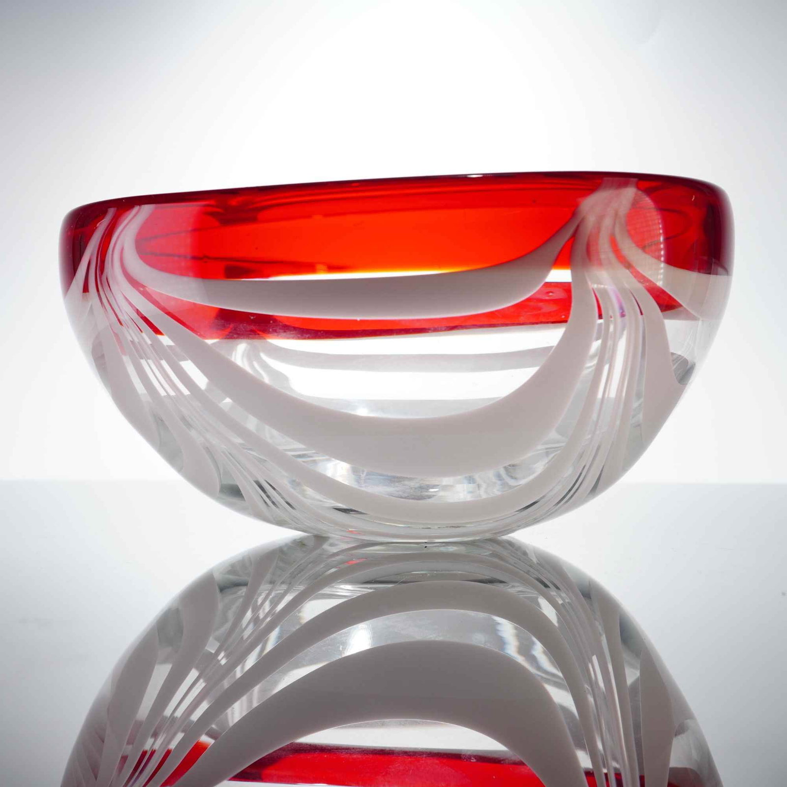 Hand-Blown White Pulled Feather Design and Red Rim Art Glass Bowl: A hand-blown art glass bowl featuring a clear glass body decorated with internal opaque white feather pulled design patterns. The upper section and wide rim are composed of translucent ruby red glass.