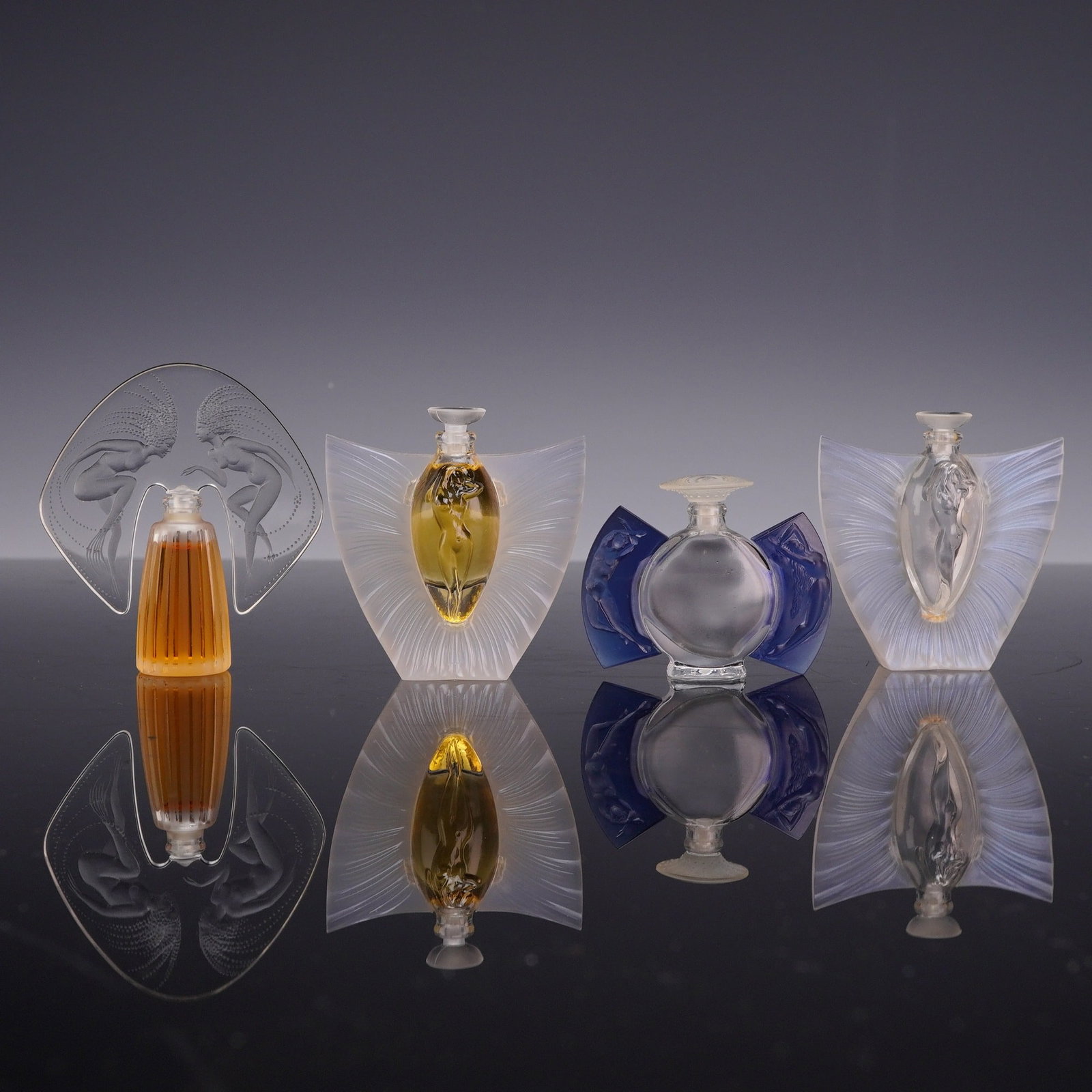 4pc Lalique Acrylic Miniature Perfume Bottles, Ondines Flacon, Sylphide Flacon, and Timeless: Collection comprises a Lalique "Ondines Flacon," a 1998 limited-edition miniature perfume bottle in polished and frosted crystal, designed in an Art Deco style and featuring two stylised female water 