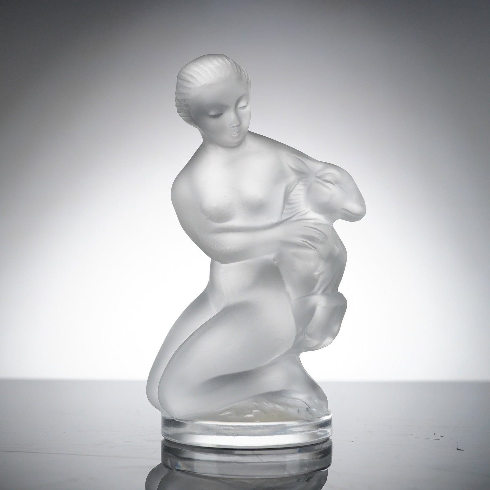 Lalique Frosted Crystal Diane Figurine: This is a frosted crystal figurine of Diane, originally designed by Rene Lalique in 1937. The small figure depicts the Roman goddess Diana as a kneeling nude woman holding a young deer or fawn. The fi