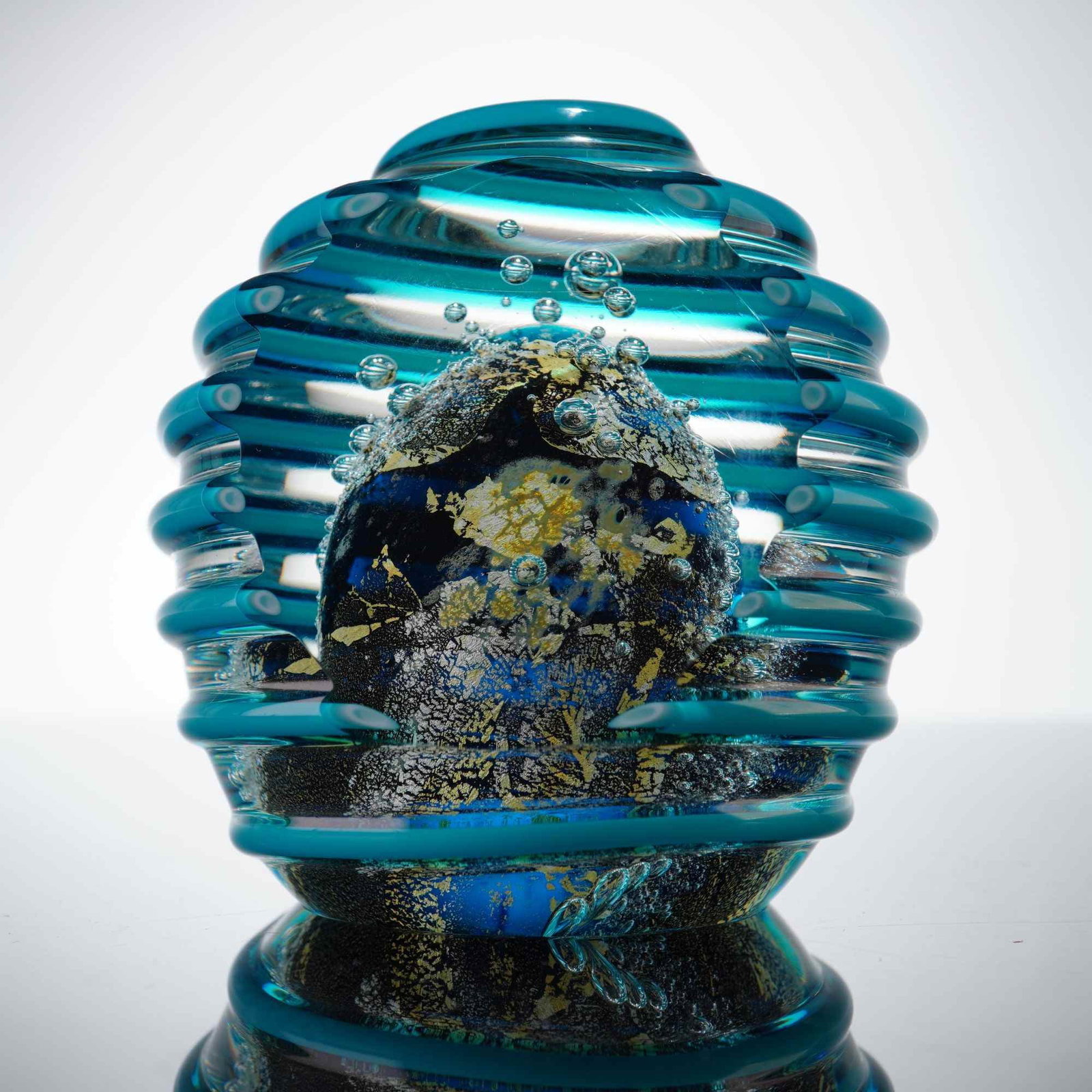 David Lindsay for Nourot Studios Bee Hive Ribbed Art Glass Paperweight: The piece is executed in the Bee Hive pattern, featuring a globular form with a heavily textured exterior. The internal construction consists of a deep cobalt blue core densely packed with metallic go