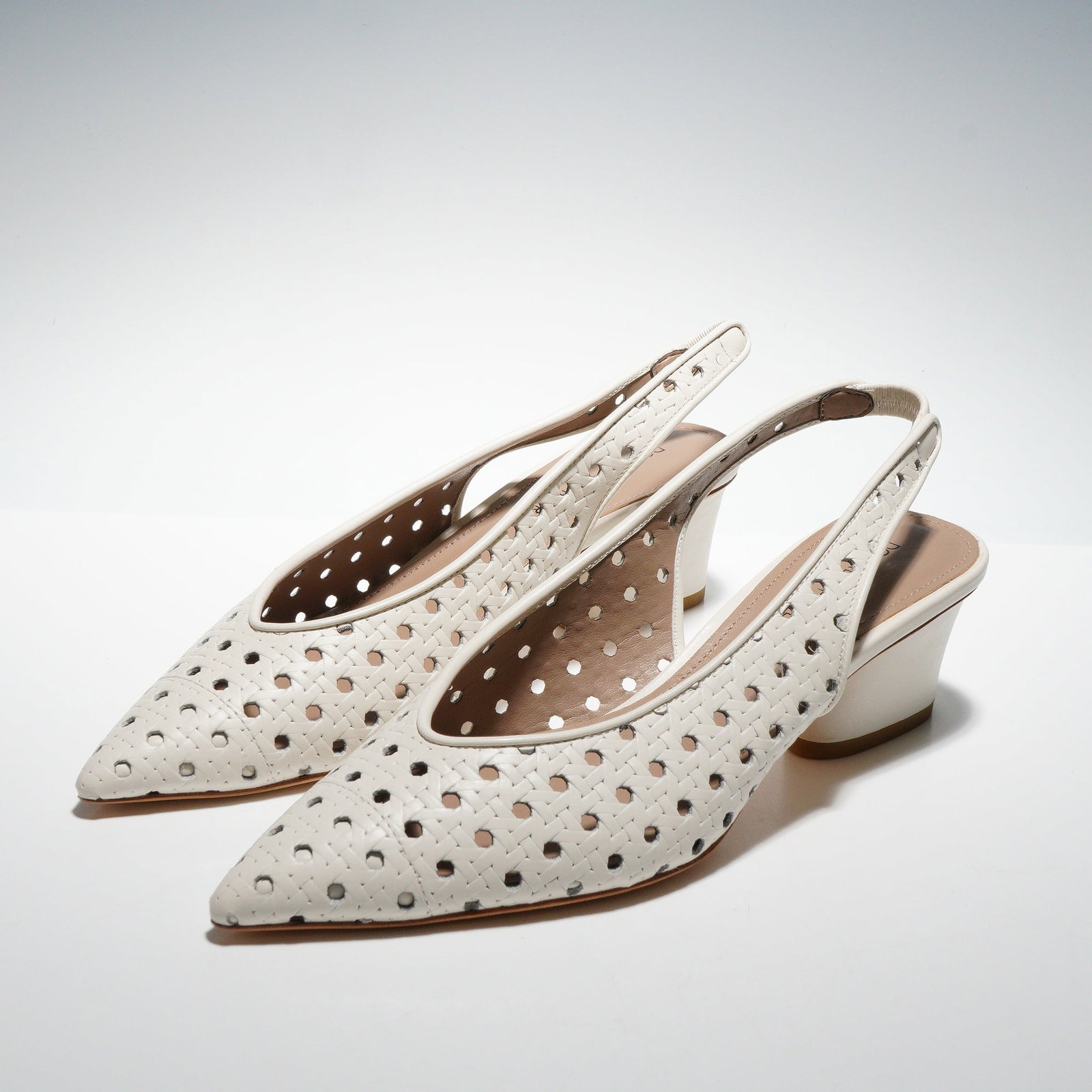 A Pair of Donald Pliner Woven Leather Slingback Pointy-Toe Pumps: A pair of Donald Pliner Gema woven leather classic slingback pumps with pointy-toe, crafted in white leather. These contemporary women's shoes feature a pointed toe and a low block heel. The upper is 