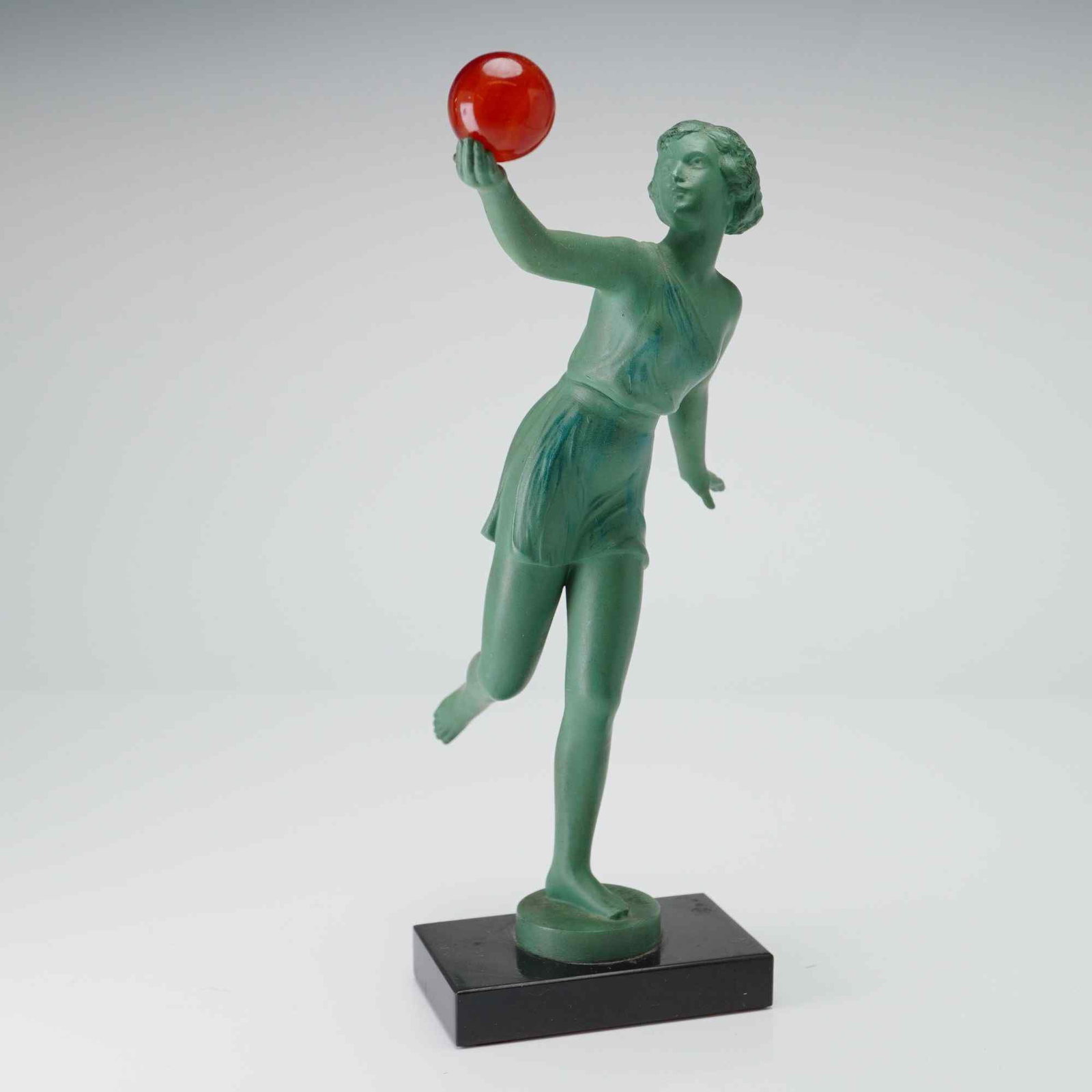 Style of Maurice Guiraud-Riviere (French 1881-1947) Art Deco Ball Dancer Figurine w Red Ball, Signed: This Art Deco style sculpture in the style of Maurice Guiraud-Riviere (French 1881-1947), features a small figurine holding a ball. The subject is depicted in a dynamic, athletic pose, wearing a short