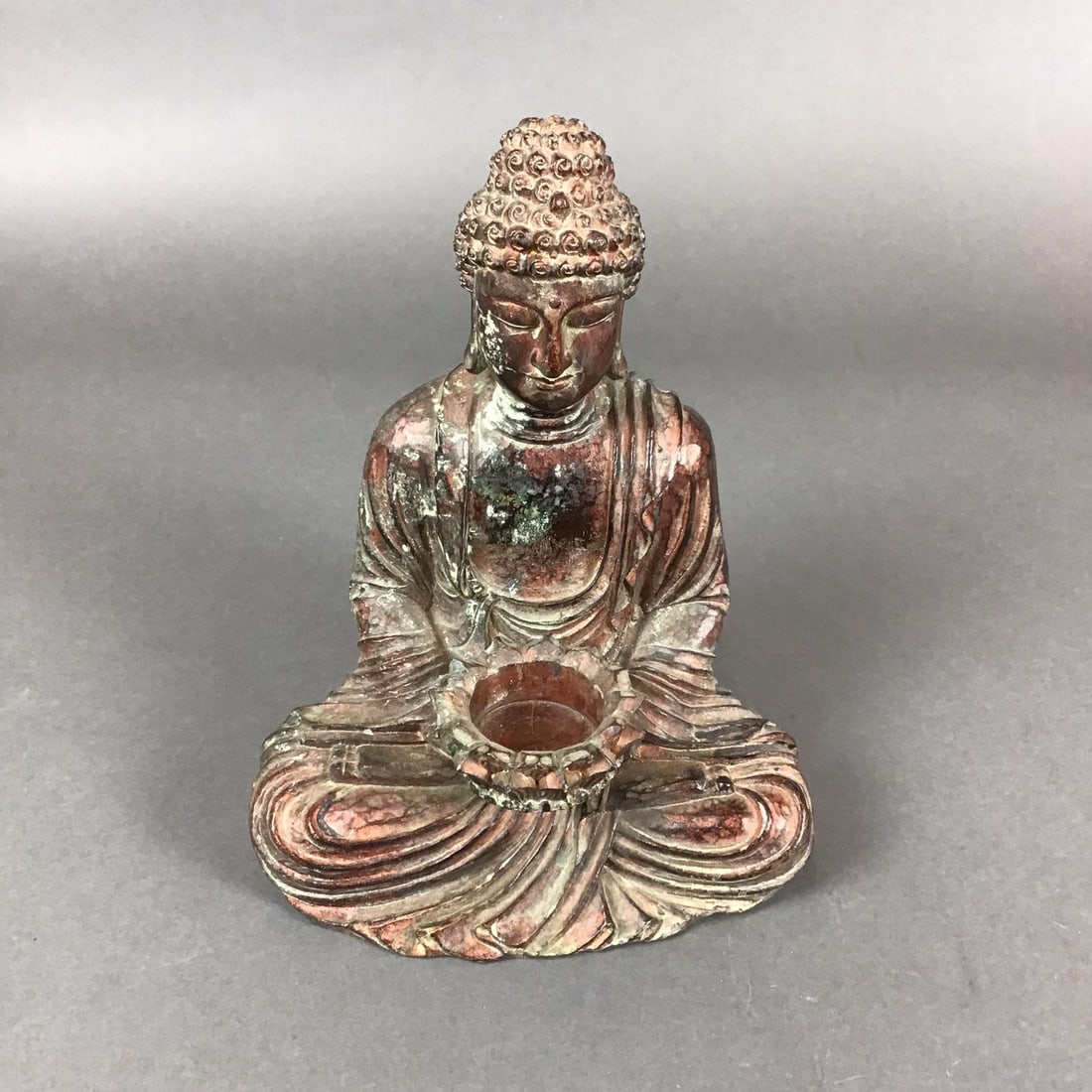 Carved Wood Seated Buddha Figure with Lotus Vessel: This carved wood seated buddha figure is presented in a meditative dhyanasana posture with hands resting in the dhyana mudra. The figure supports a lotus-shaped vessel, a form often associated with Bh