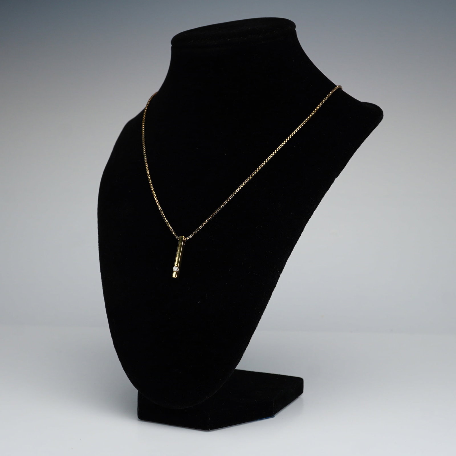 JWBR Gold-Plated Sterling Silver Diamond Vertical Bar Pendant Necklace: A gold plated sterling silver vertical bar pendant set with a single diamond. The pendant suspends from a rope chain with a lobster clasp. Both pendant and chain are marked 925, with the pendant furth