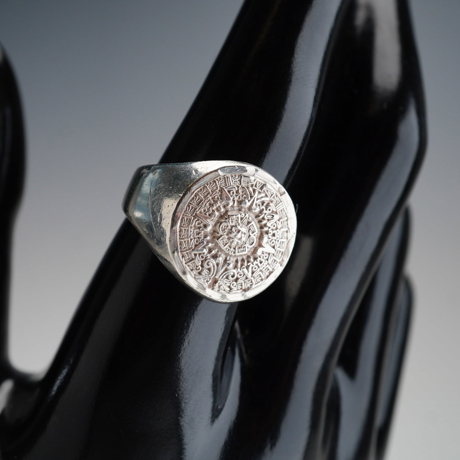 Mexican Sterling Silver Aztec Calendar Ring: A sterling silver signet ring engraved with the Aztec calendar. The band is marked 925. Dimensions: Ring size: 9.5 Weight: 10.8 g