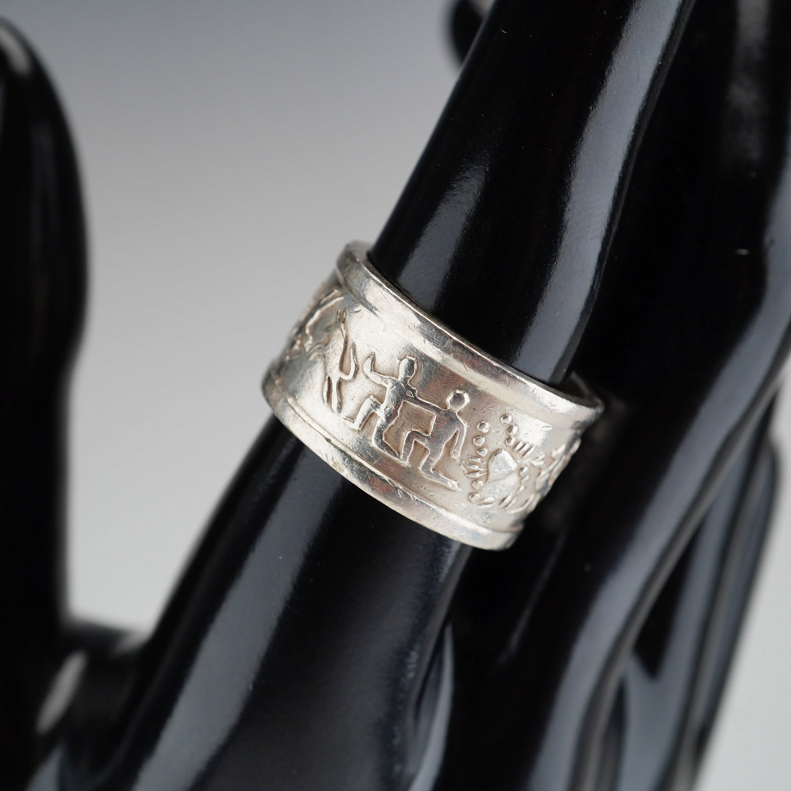 Sterling Silver Zodiac Band Ring: A wide sterling silver band featuring a raised relief design depicting Zodiac signs. Marked 925. Dimensions: Ring size: 9.25 Weight: 13.6 g