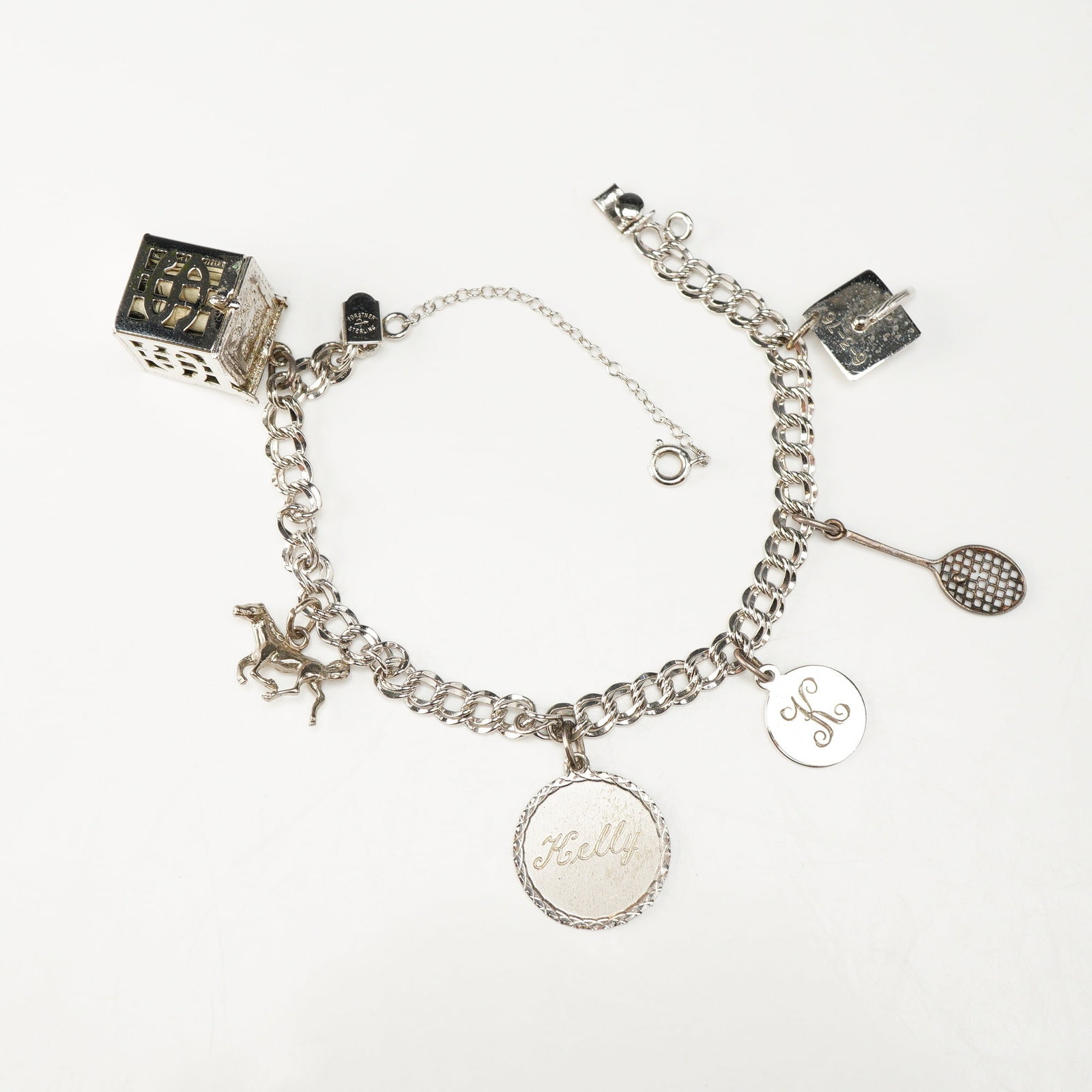Forstner Sterling Silver 925 Double Link Charm Bracelet with Six Charms: This vintage sterling silver charm bracelet is composed of a double-link curb chain. The piece is secured with a fold-over clasp and a secondary spring-ring safety chain. The clasp is stamped with the