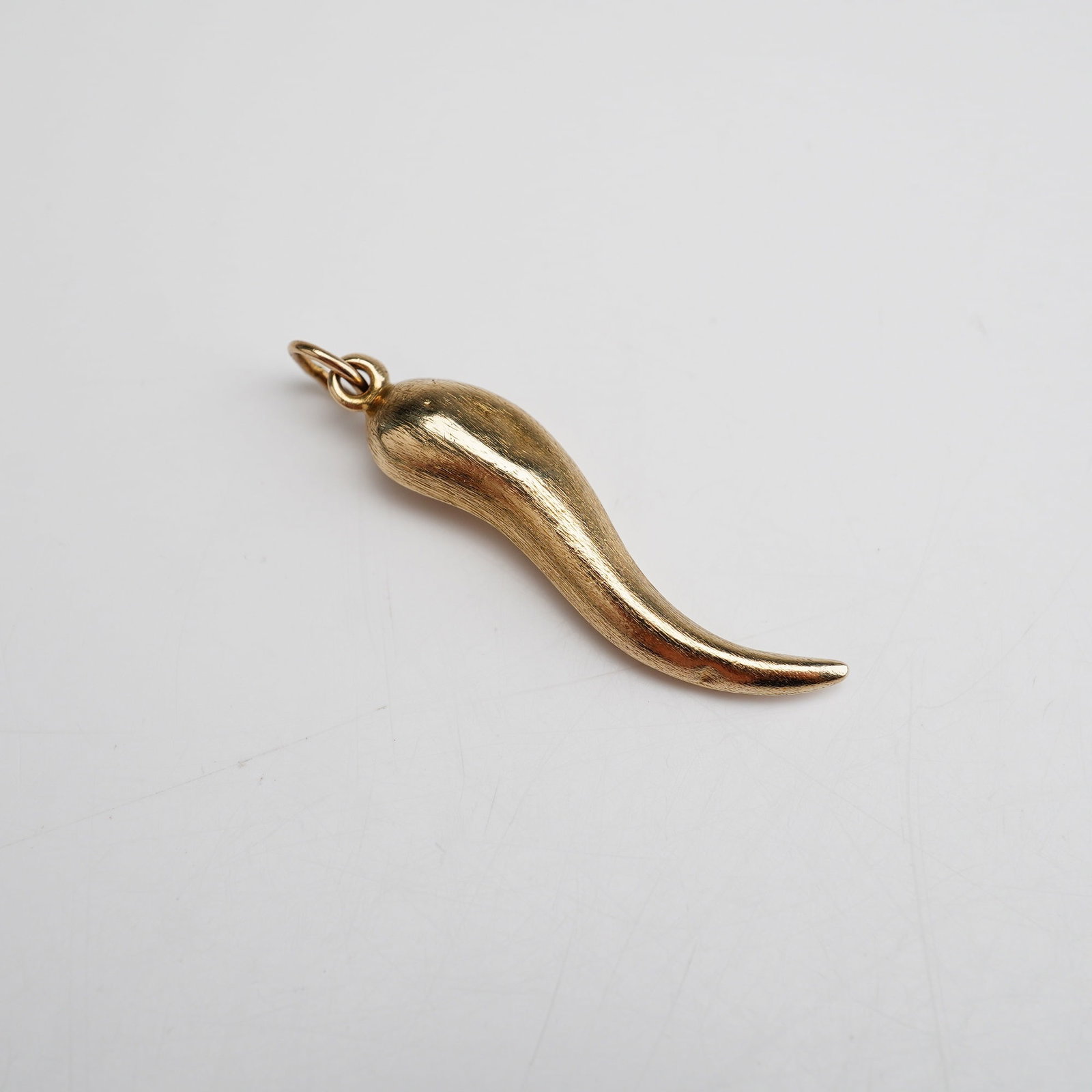 14K Gold Italian Cornicello Pendant: A 14K yellow gold pendant in the shape of a little horn. Marked 14K on the bail. Dimensions: 1.5"L Weight: 0.85 g