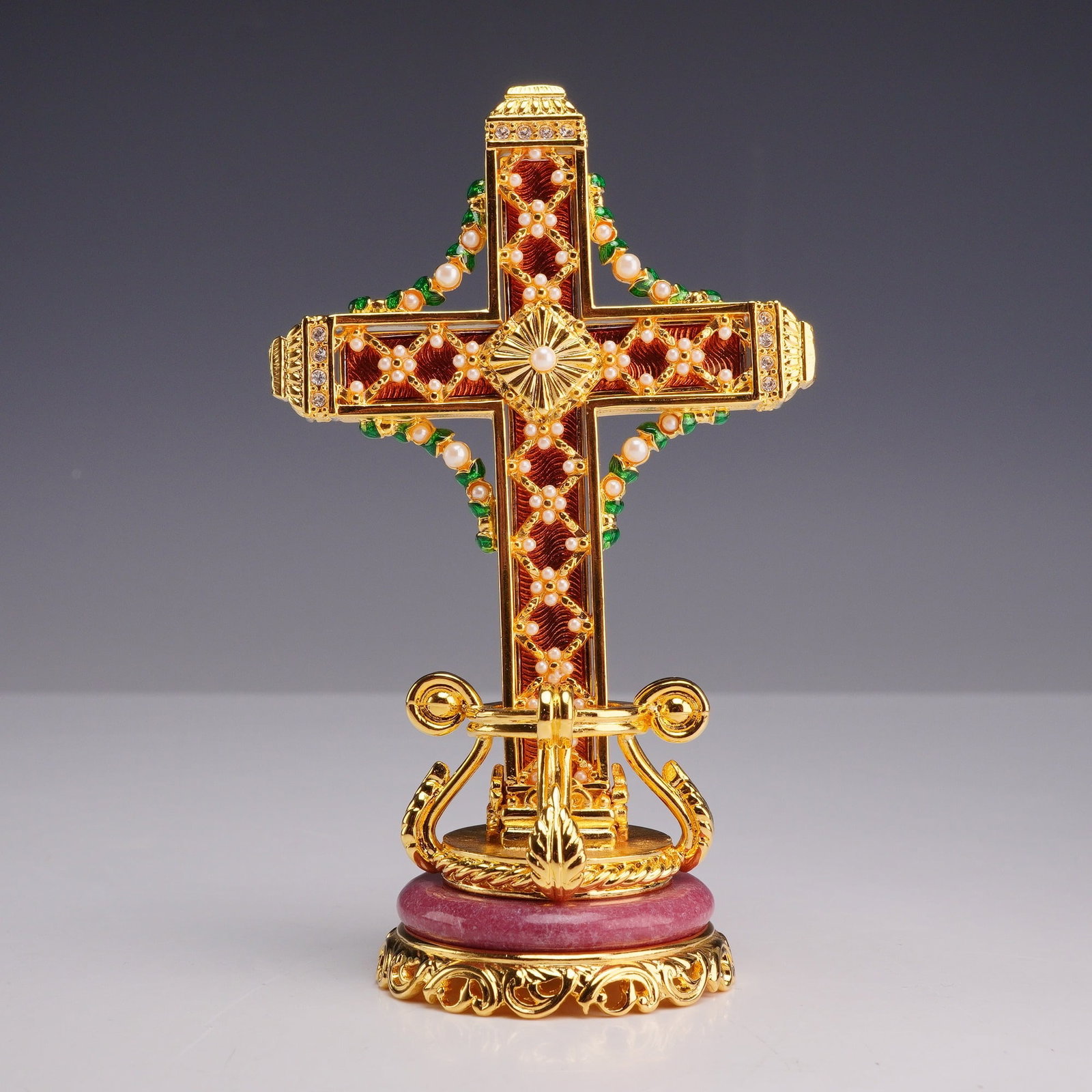 Faberge Rose Trellis Enamel and Pearl-Set Standing Cross with Stand: A modern Faberge decorative standing cross featuring a detachable pendant cross and an ornate display stand. The cross is decorated with translucent red enamel over an engine-turned ground, accented b