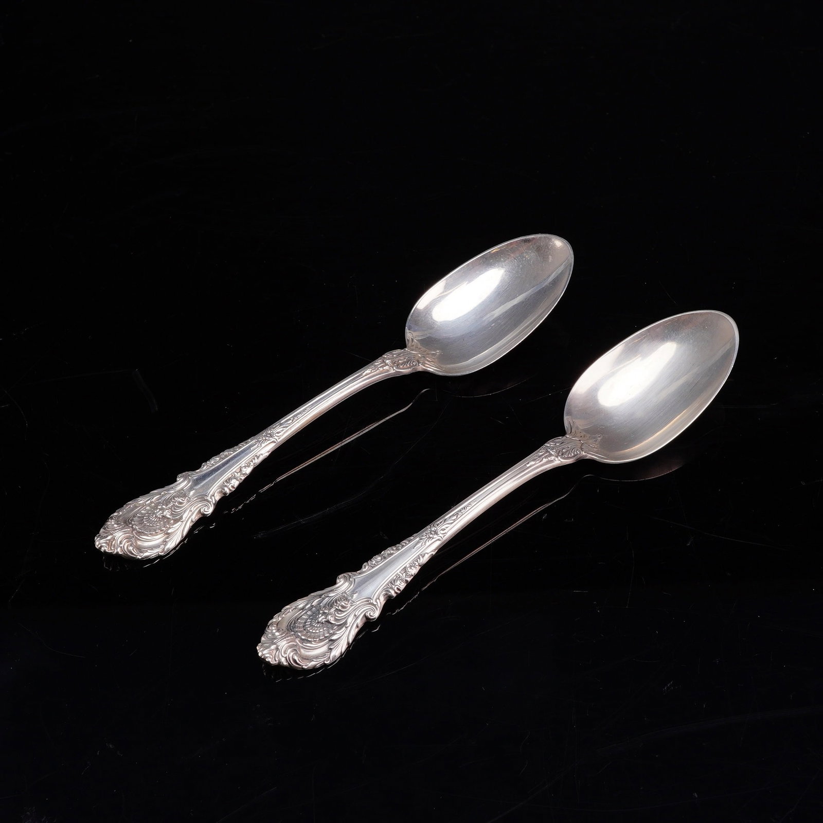 A Pair of Wallace Sterling Silver Dessert Teaspoons in the Sir Christopher Pattern: A pair of solid sterling silver dessert spoons manufactured by Wallace Silversmiths of Wallingford, Connecticut, in the Sir Christopher pattern. Introduced in 1936, this pattern features heavy Rococo 