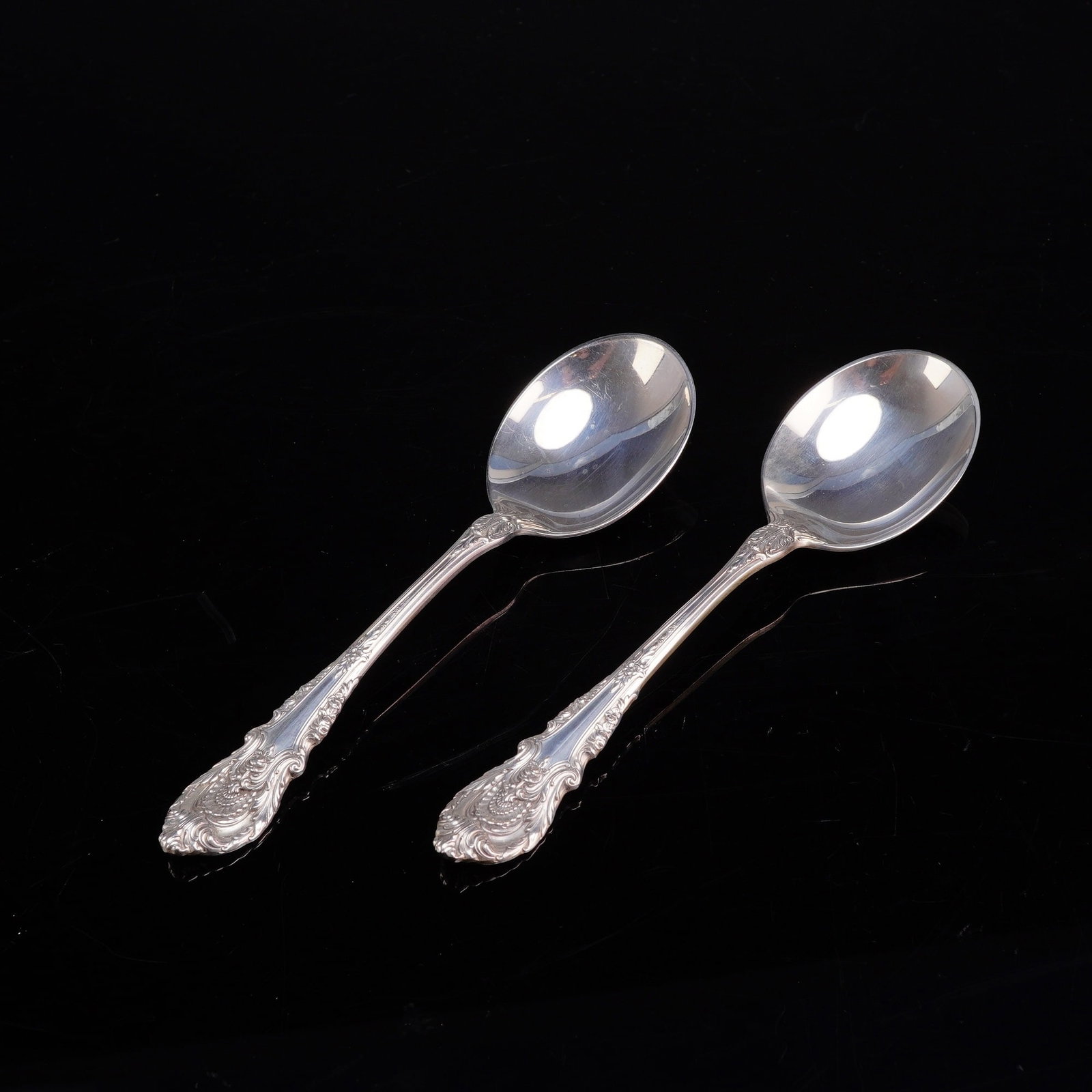 A Pair of Wallace Sterling Silver Soup Spoons in the Sir Christopher Pattern: A pair of Wallace sterling silver soup spoons in the Sir Christopher pattern. These items are crafted from solid .925 silver. The handles are decorated with elaborate high-relief scrolling foliage, fl