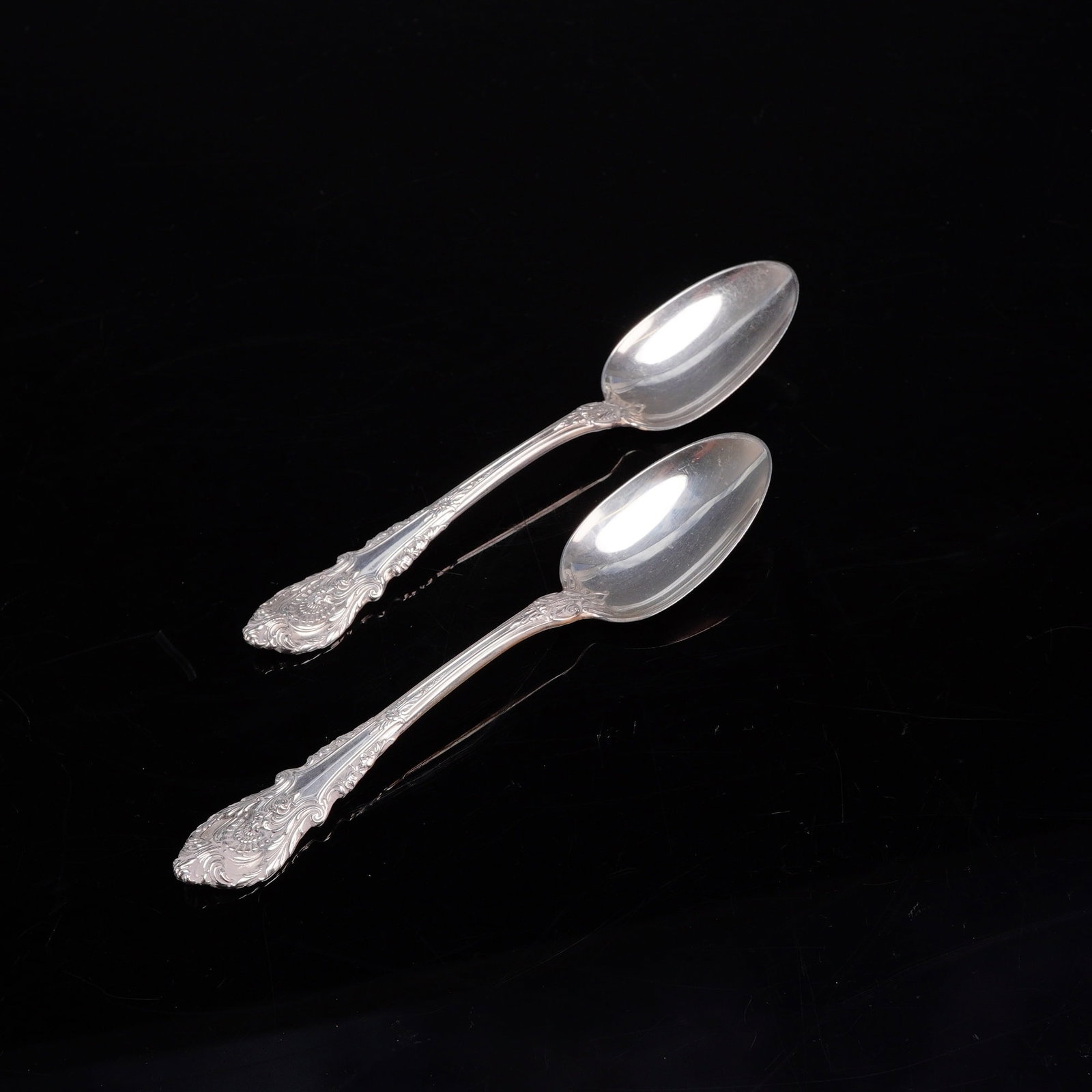 A Pair of Wallace Sterling Silver Teaspoons in the Sir Christopher Pattern: A pair of American sterling silver teaspoons manufactured by Wallace Silversmiths in the Sir Christopher pattern. This pattern, introduced in 1936, is characterized by its ornate handle featuring high